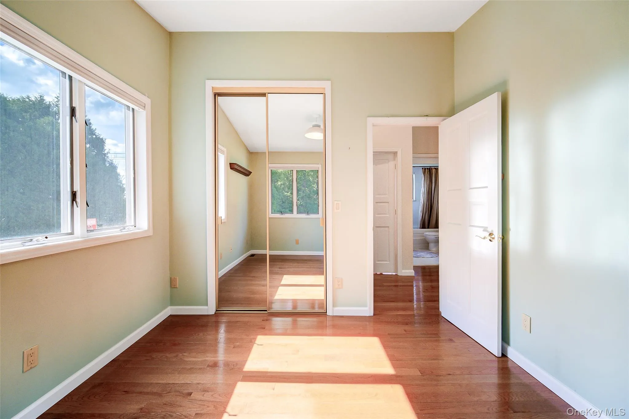 Bedroom 2 has hardwood flooring, mirrored closet doors, windows allowing for plenty of natural light Bedroom 2 has hardwood flooring, mirrored closet doors, windows allowing for plenty of natural light