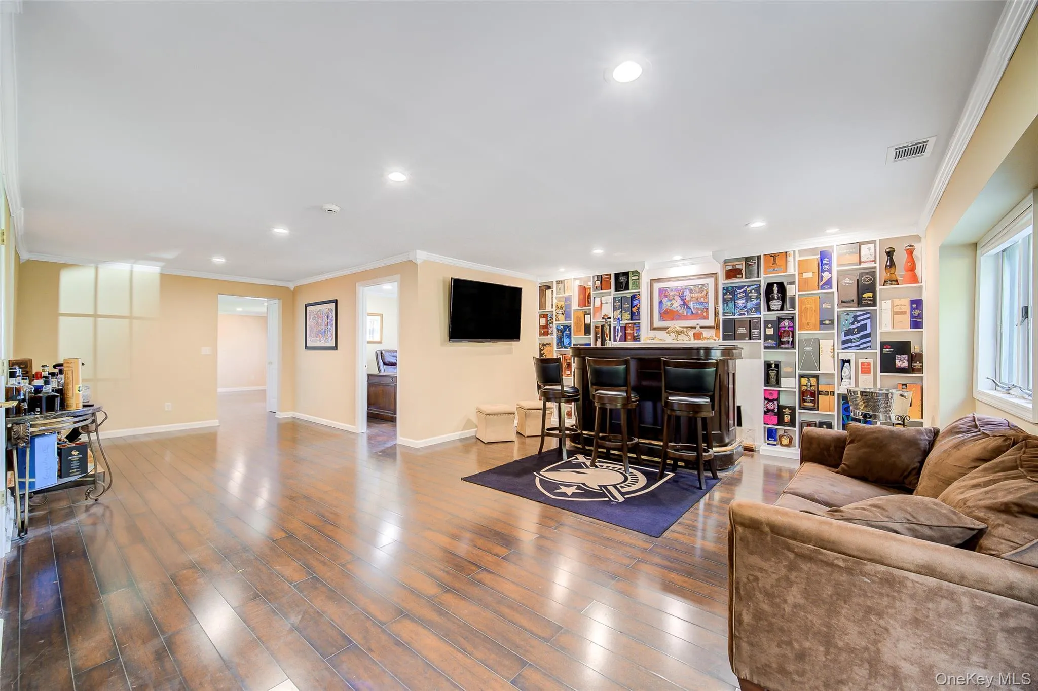 Spacious room featuring wood-finish flooring, recessed lighting, and custom built in storage. Spacious room featuring wood-finish flooring, recessed lighting, and custom built in storage.