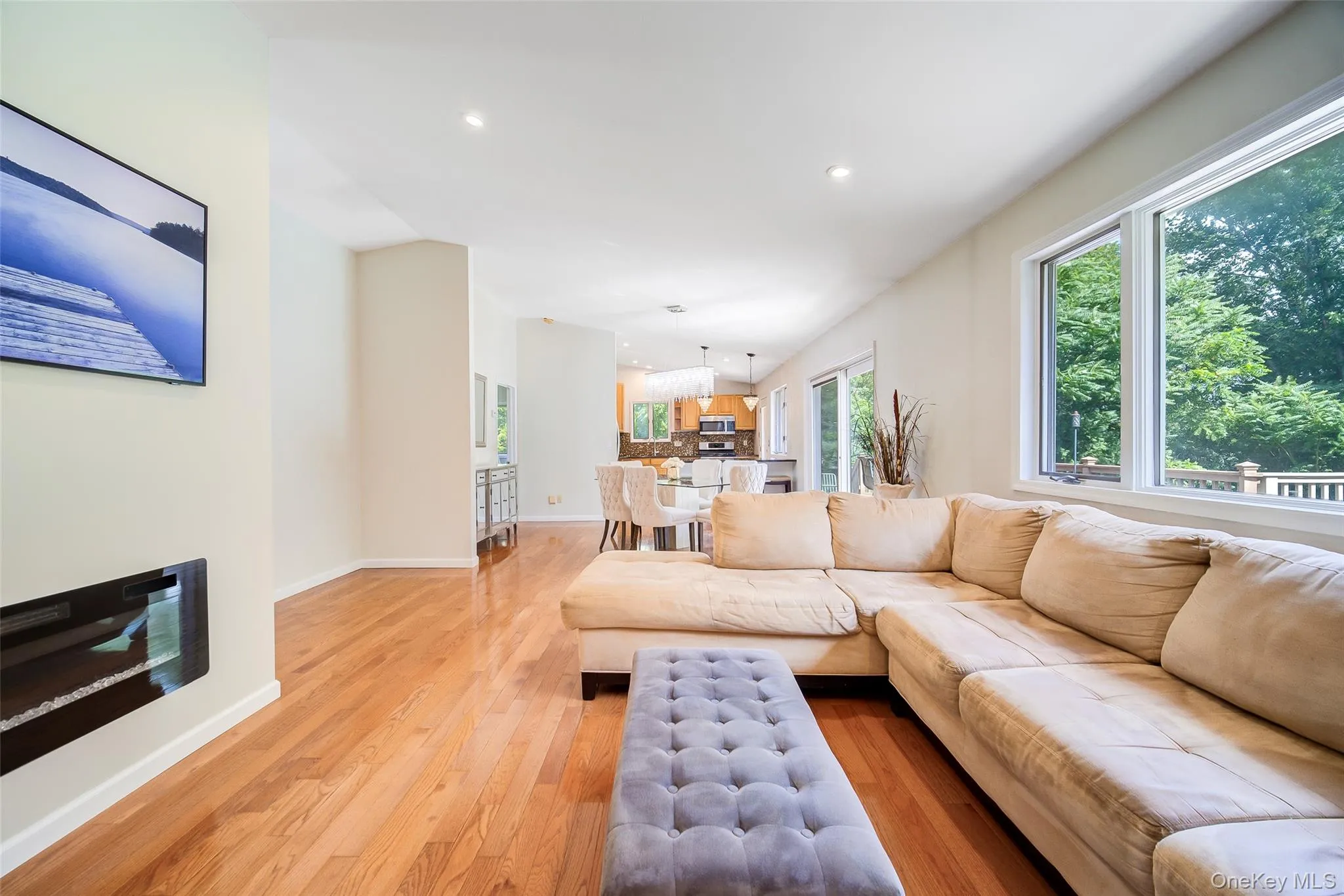 Hardwood flooring, recessed lighting, expansive windows, built-in fireplace, and an open-concept layout Hardwood flooring, recessed lighting, expansive windows, built-in fireplace, and an open-concept layout