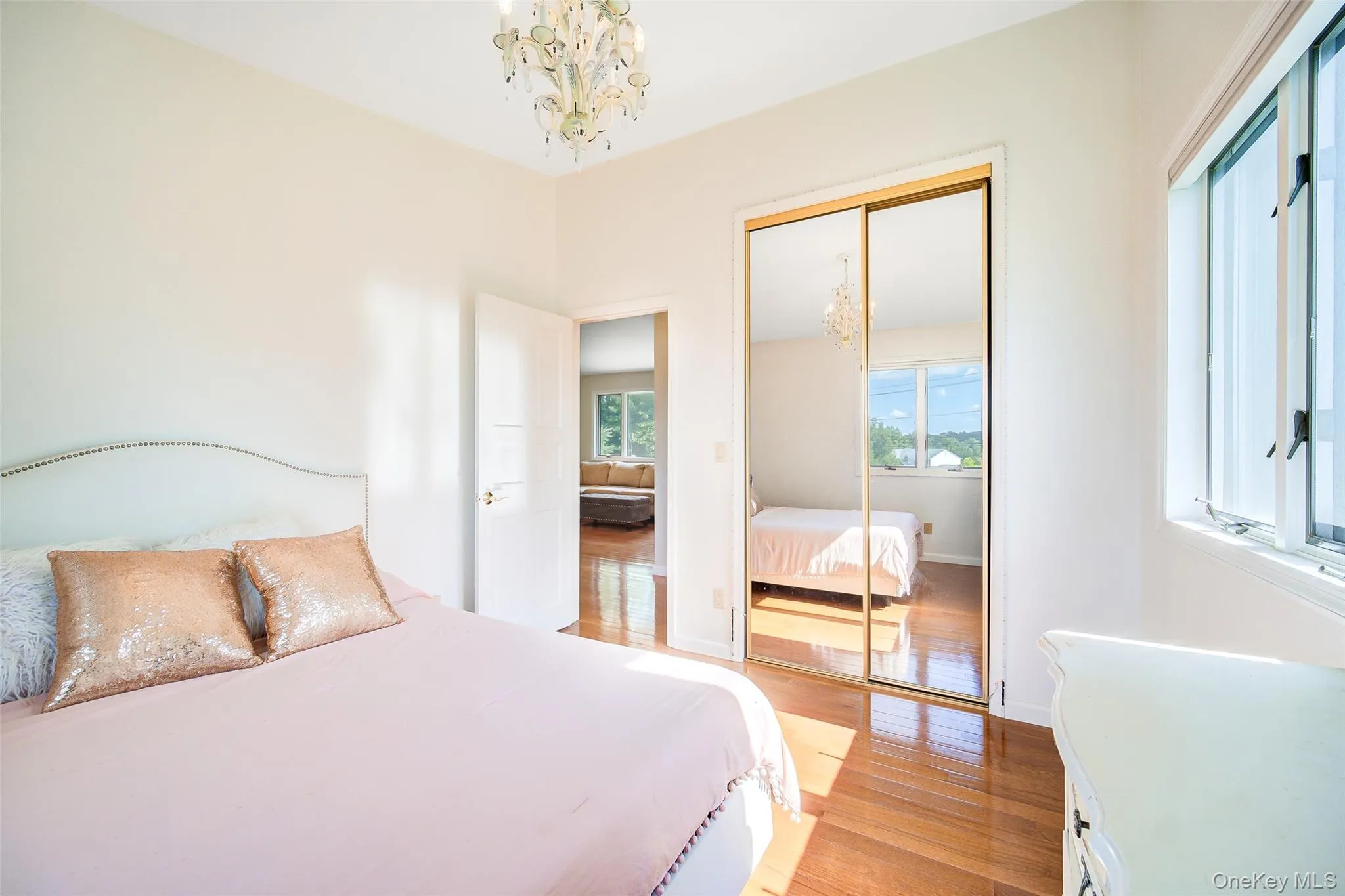 Hardwood-finish flooring, mirrored closet doors, a detailed chandelier, and large casement windows Hardwood-finish flooring, mirrored closet doors, a detailed chandelier, and large casement windows