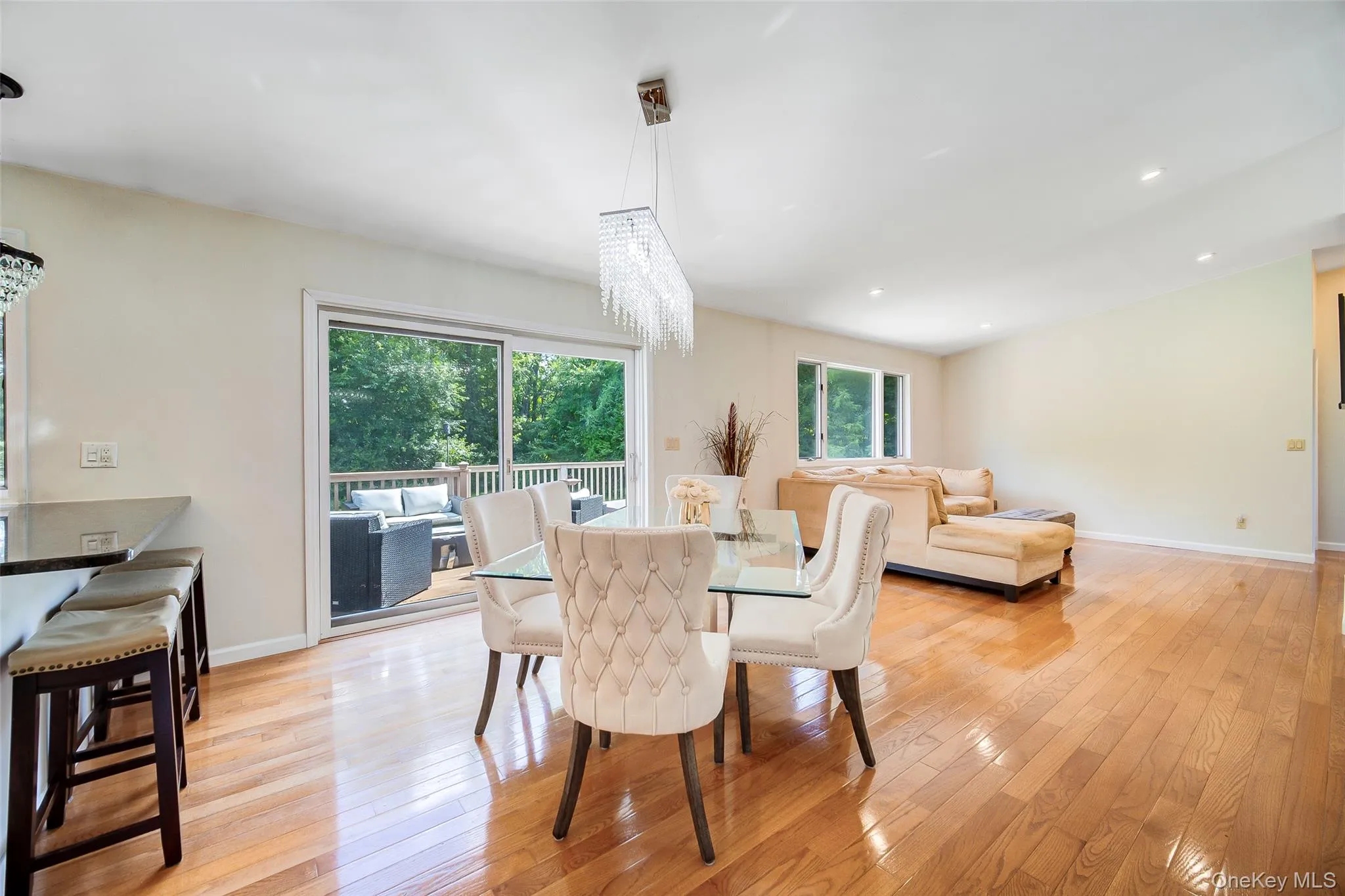 Wood-finish flooring, recessed lighting, and a linear crystal chandelier Wood-finish flooring, recessed lighting, and a linear crystal chandelier