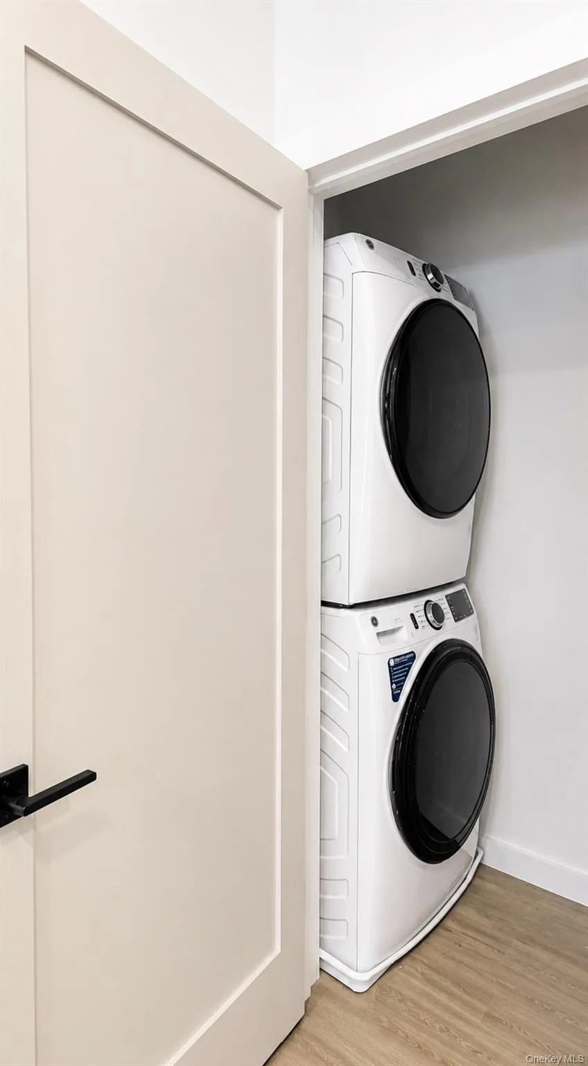 Closet laundry area featuring a white stackable washer and dryer Closet laundry area featuring a white stackable washer and dryer