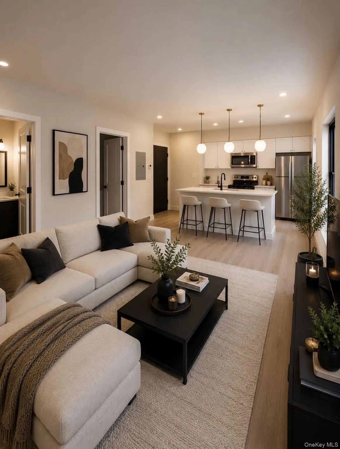Open-concept living space featuring wood-finish flooring, recessed lighting, and a kitchen island with pendant lighting Open-concept living space featuring wood-finish flooring, recessed lighting, and a kitchen island with pendant lighting