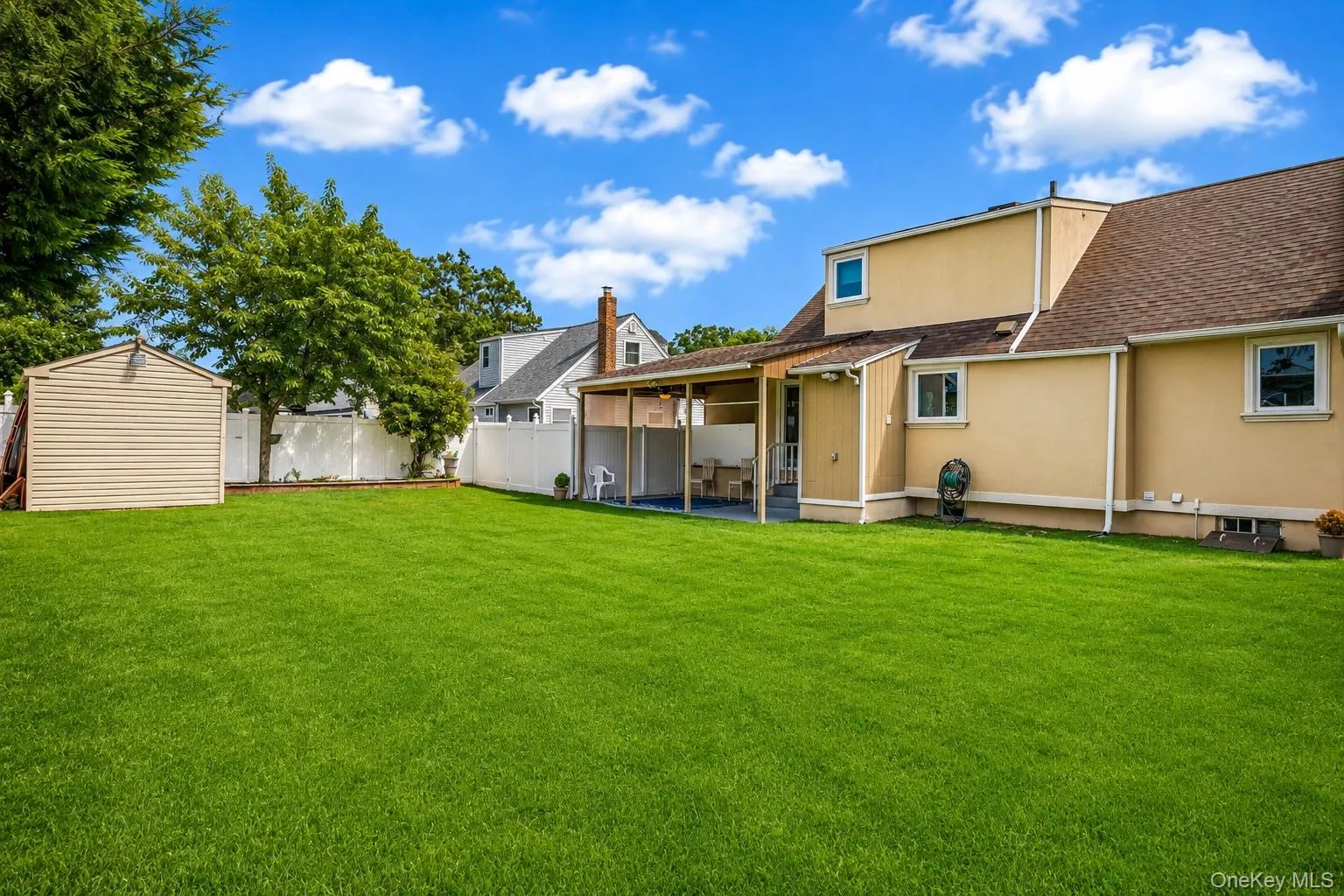 Expansive grassy yard with a white privacy fence Expansive grassy yard with a white privacy fence