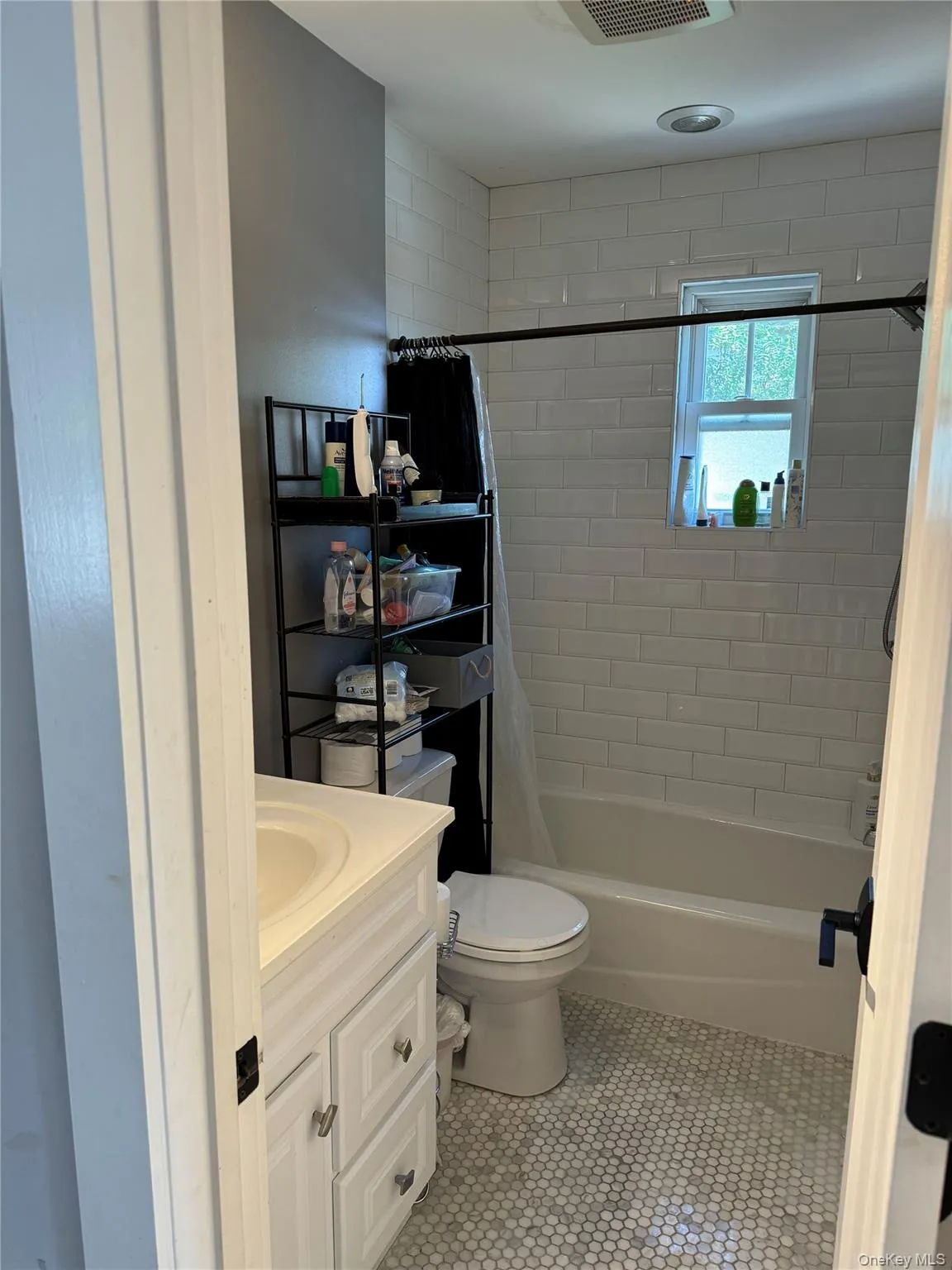 Bathroom with shower / bath combo with shower curtain, vanity, and light tile patterned floors Bathroom with shower / bath combo with shower curtain, vanity, and light tile patterned floors