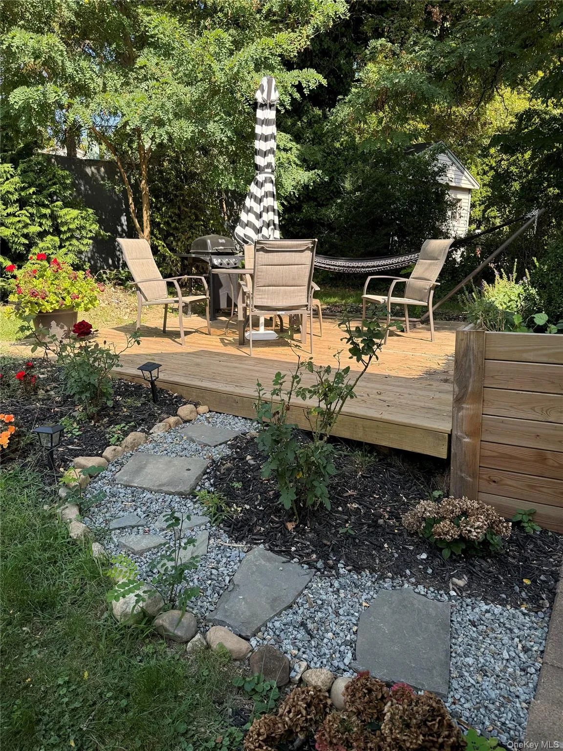 View of yard featuring a wooden deck and outdoor dining area View of yard featuring a wooden deck and outdoor dining area