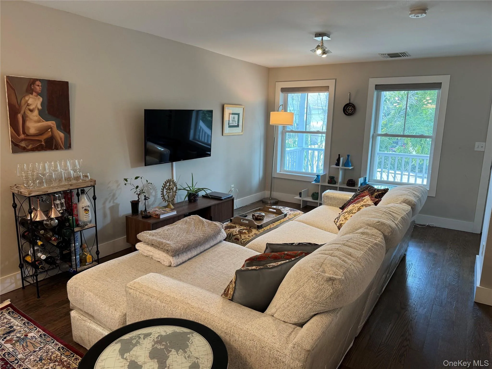 Living area featuring dark wood-type flooring and baseboards Living area featuring dark wood-type flooring and baseboards
