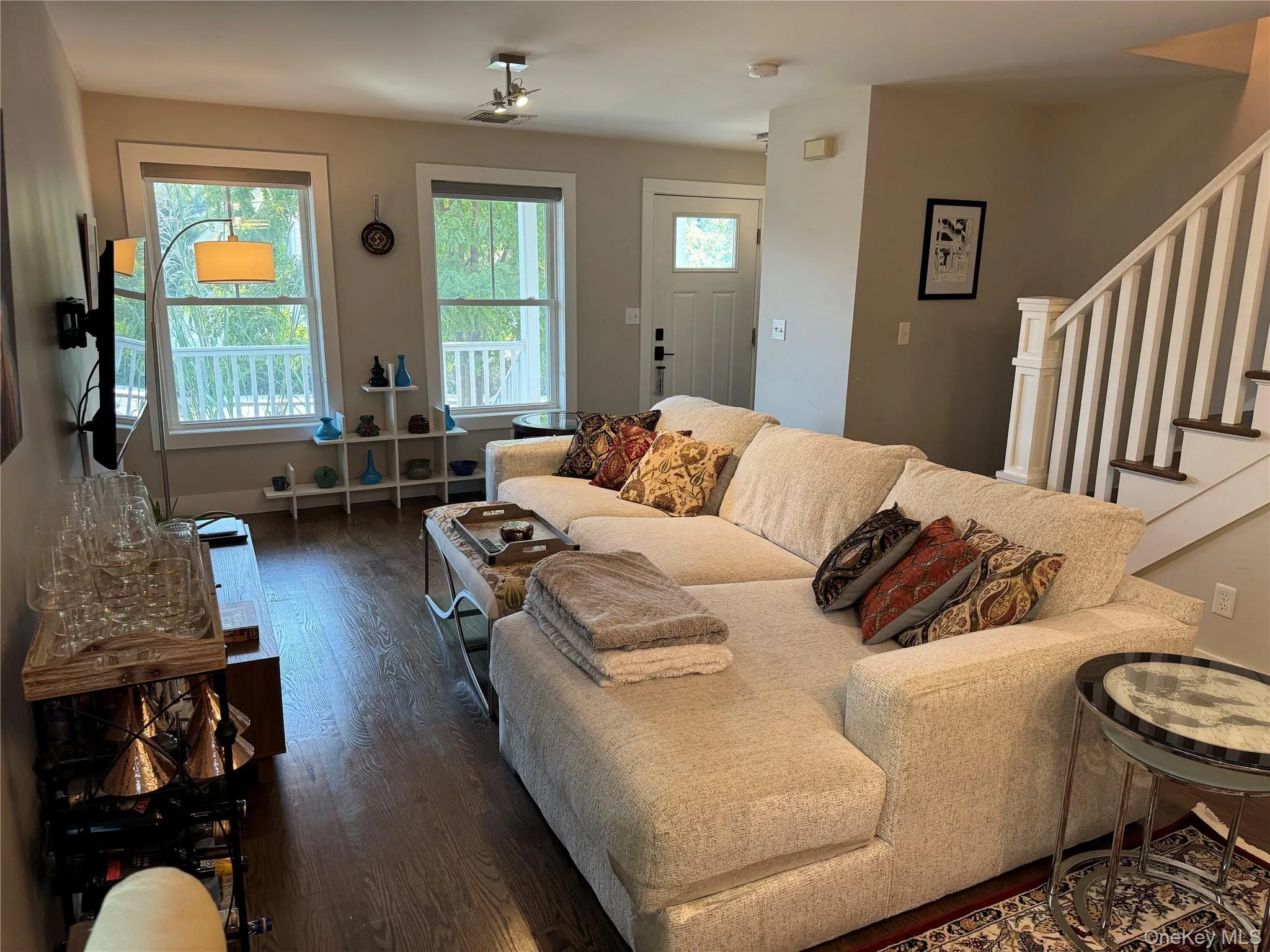 Living room with stairs and dark wood-style flooring Living room with stairs and dark wood-style flooring