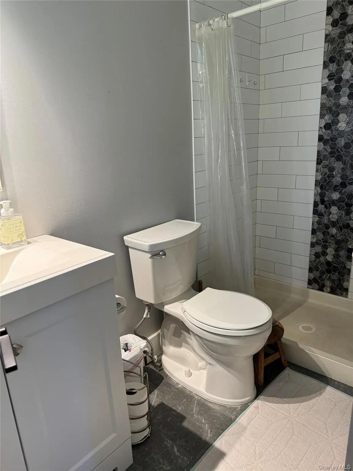 Full bathroom with a shower stall, vanity, and light tile patterned flooring Full bathroom with a shower stall, vanity, and light tile patterned flooring