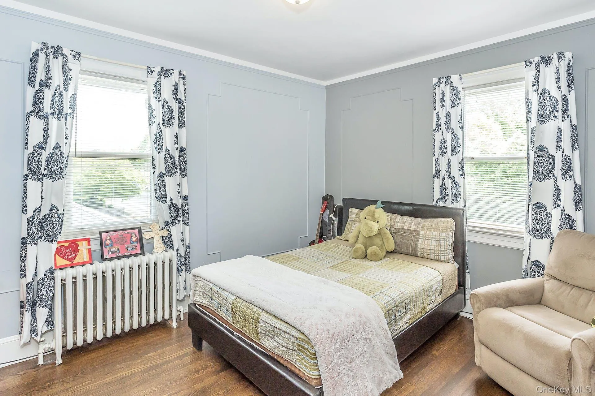 Hardwood flooring, crown molding, paneled wall detailing, and two windows providing ample natural light Hardwood flooring, crown molding, paneled wall detailing, and two windows providing ample natural light