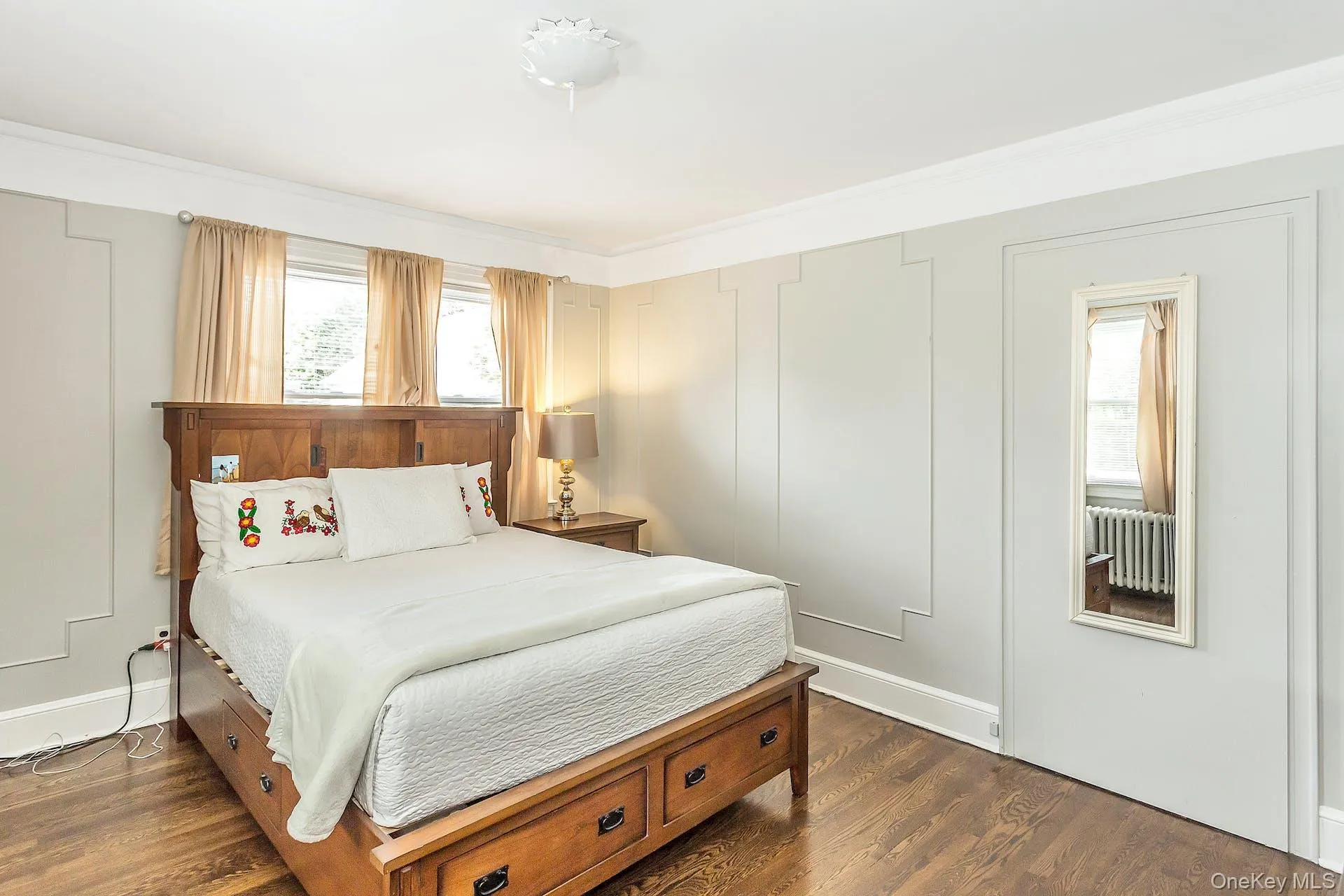 Hardwood flooring, decorative wall paneling, crown molding, and multiple windows Hardwood flooring, decorative wall paneling, crown molding, and multiple windows