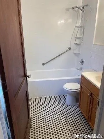 White bathtub with integrated shower, chrome fixtures, and a grab bar White bathtub with integrated shower, chrome fixtures, and a grab bar