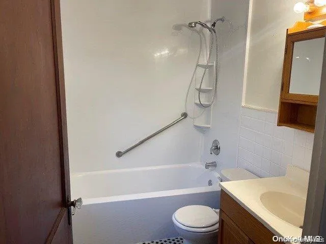 Tub/shower combination with a grab bar and integrated shelving unit Tub/shower combination with a grab bar and integrated shelving unit
