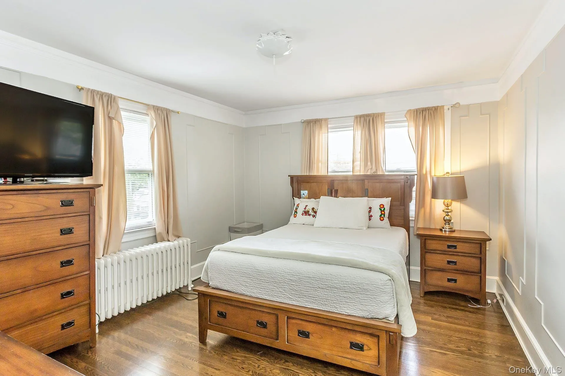 Hardwood flooring, crown molding, wall paneling, ceiling medallion, and multiple windows Hardwood flooring, crown molding, wall paneling, ceiling medallion, and multiple windows