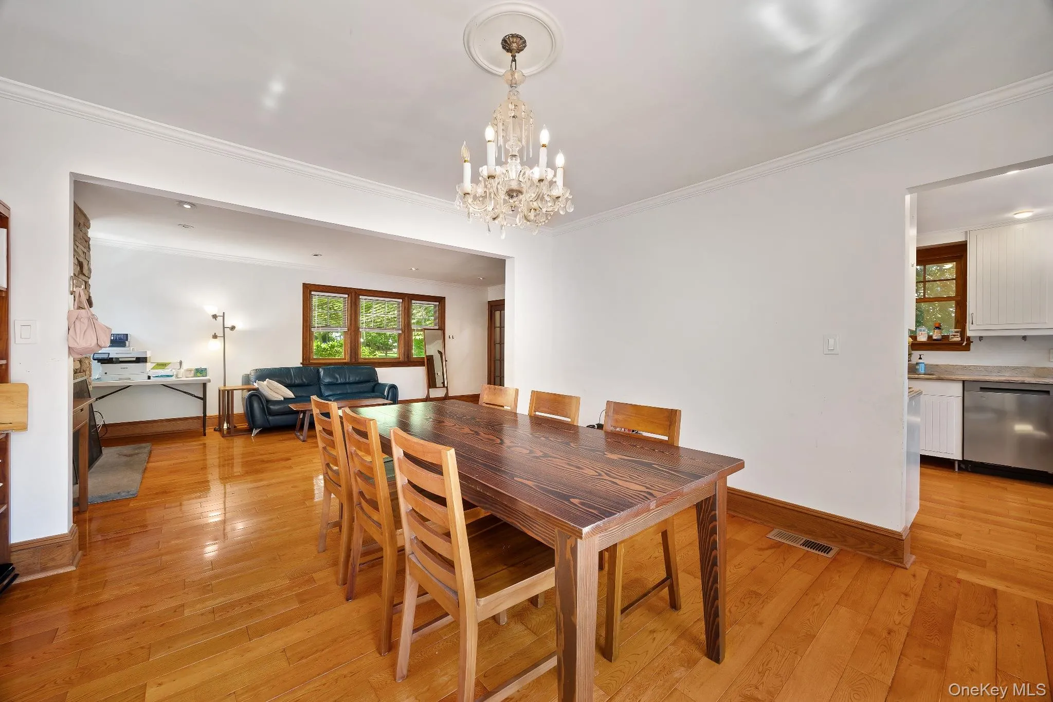 Dining room featuring light wood-style floors, crown molding, and a chandelier Dining room featuring light wood-style floors, crown molding, and a chandelier