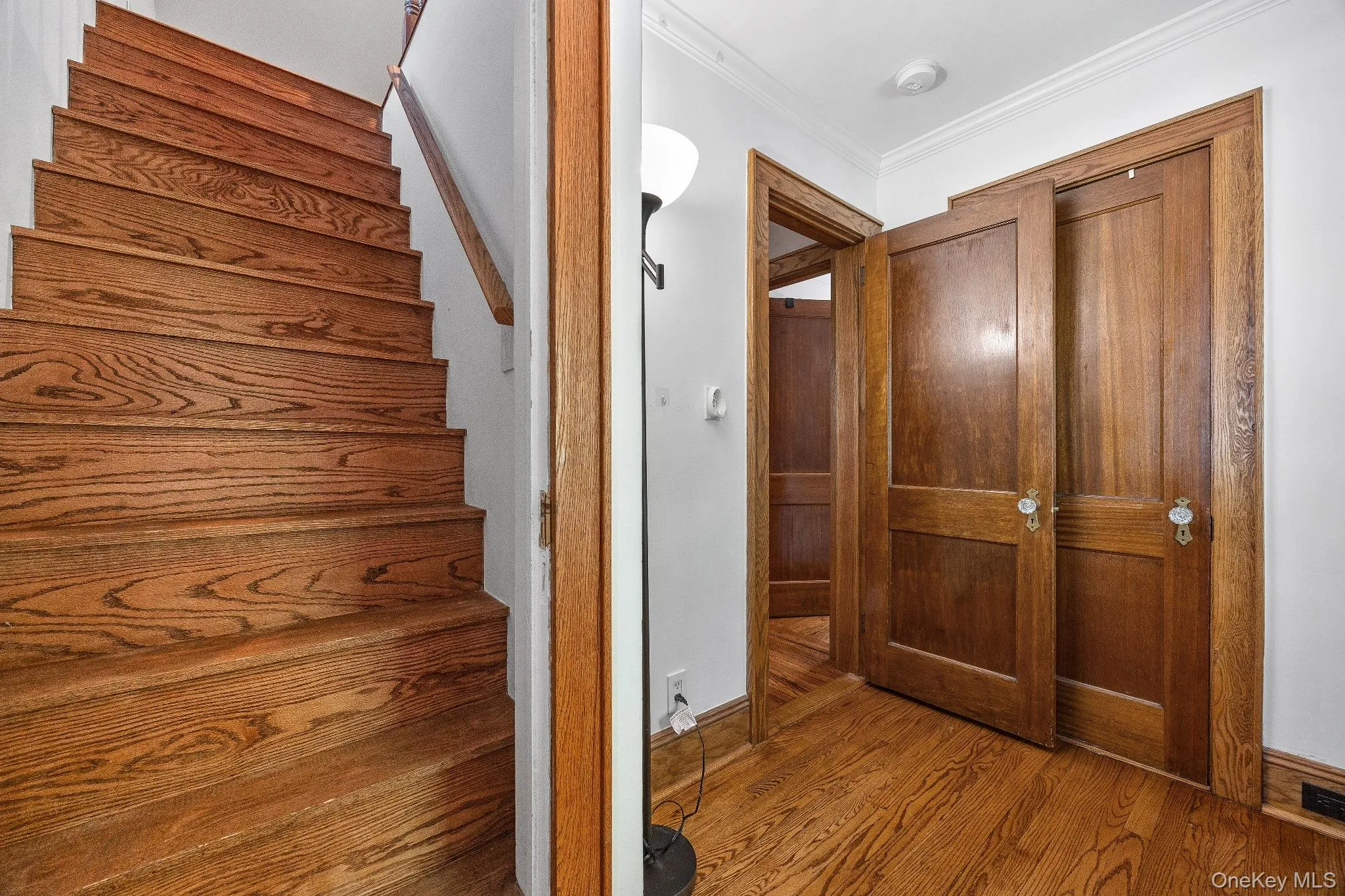 Staircase with ornamental molding and wood finished floors Staircase with ornamental molding and wood finished floors