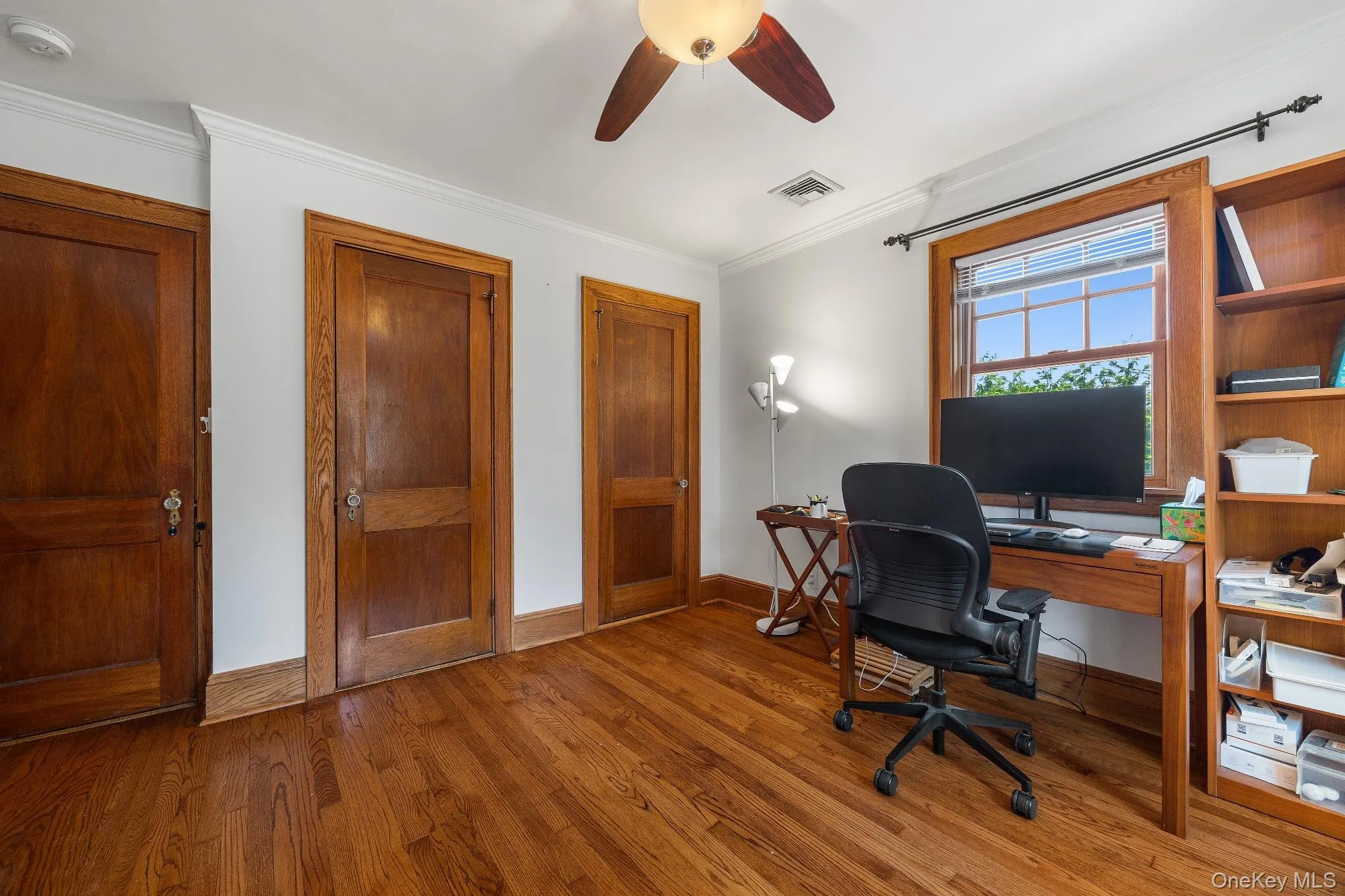 Home office featuring crown molding, wood finished floors, and ceiling fan Home office featuring crown molding, wood finished floors, and ceiling fan