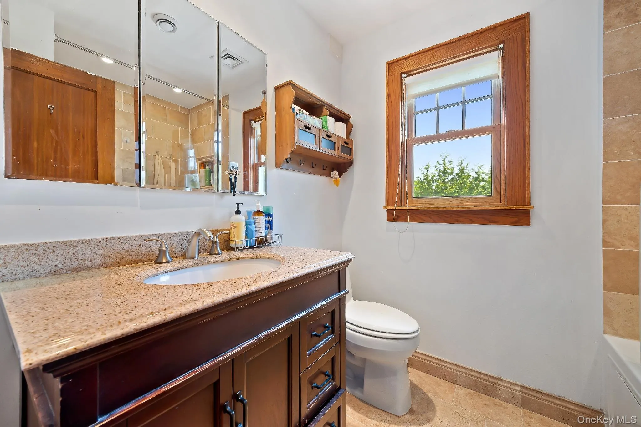 Full bath featuring vanity and light tile patterned floors Full bath featuring vanity and light tile patterned floors