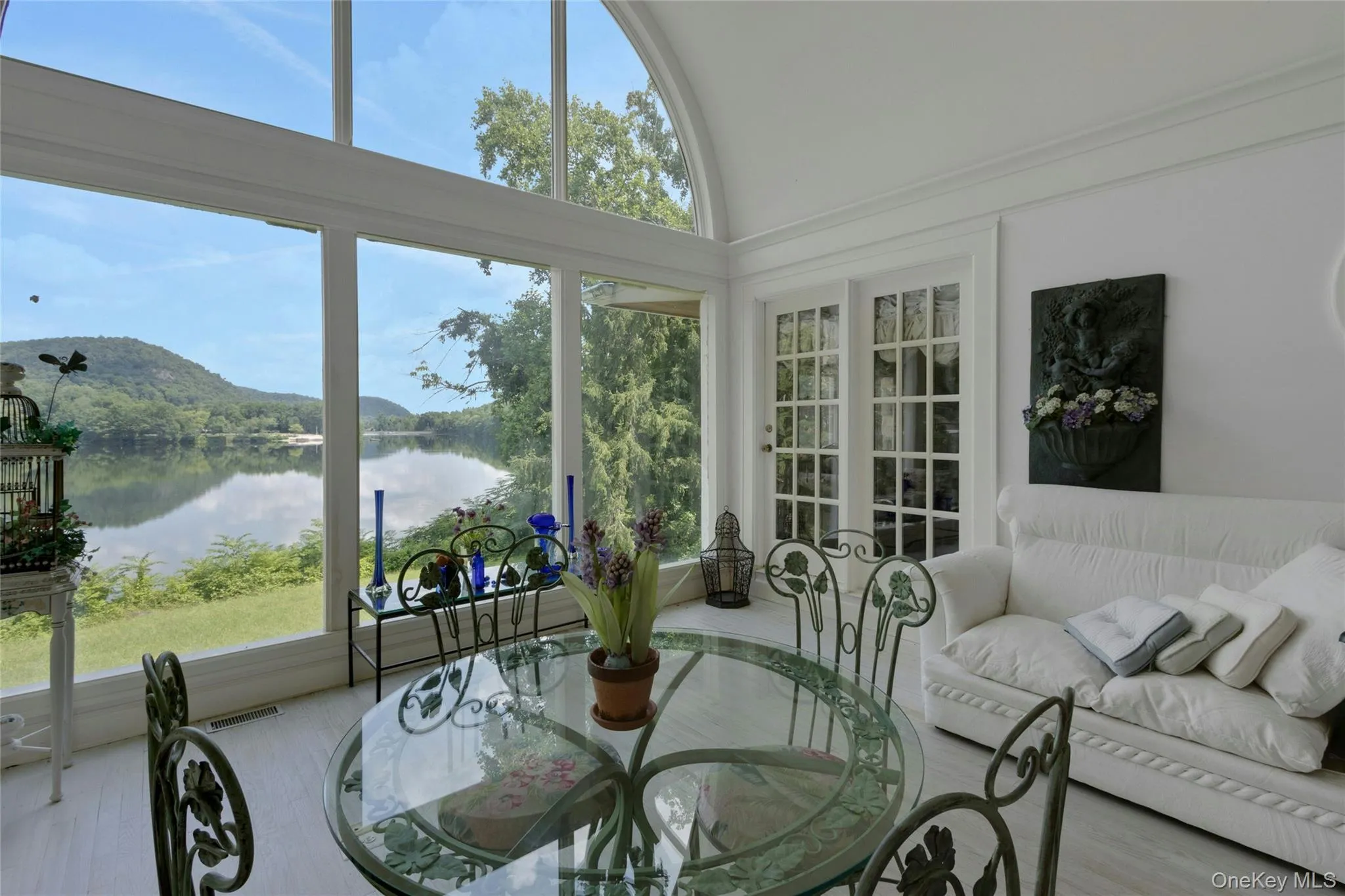 Sun room with views of the lawn and lake Sun room with views of the lawn and lake