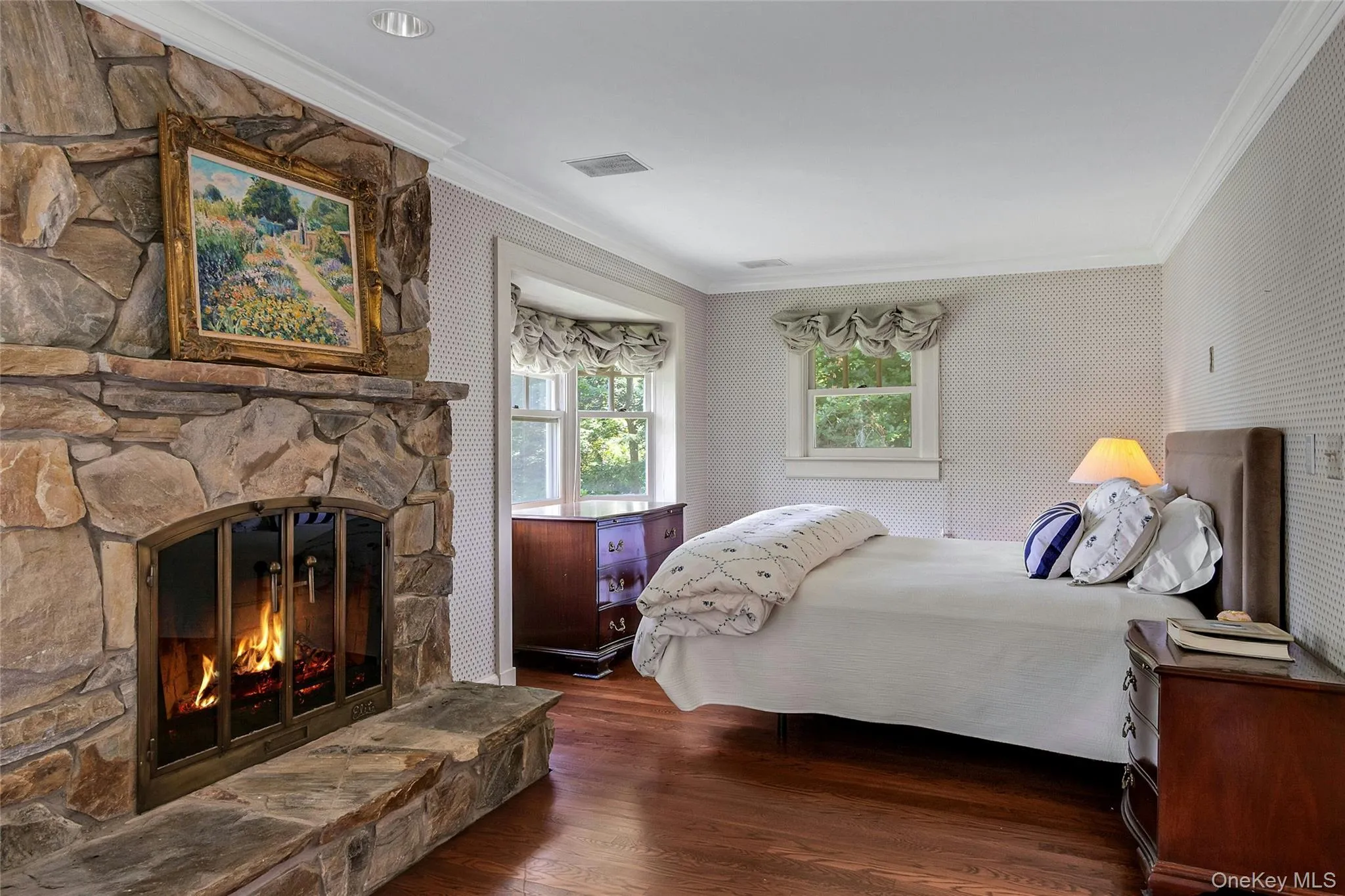 Primary bedroom with fireplace and views of Wee Wah Lake and Ramapo Mountains Primary bedroom with fireplace and views of Wee Wah Lake and Ramapo Mountains
