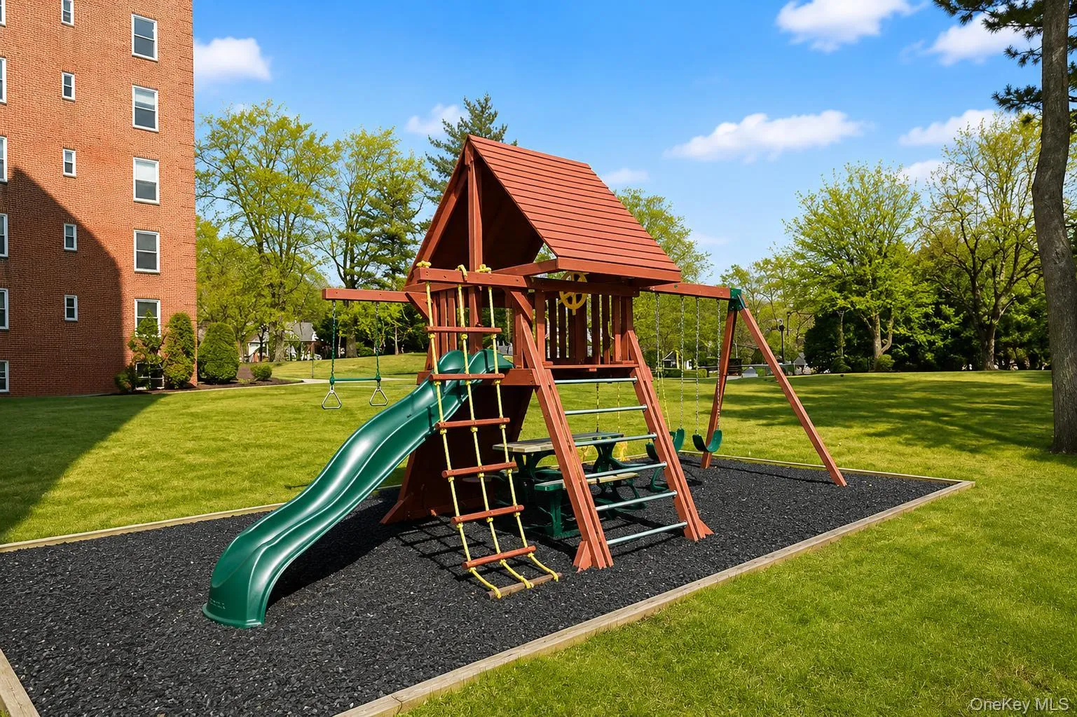 Outdoor playground with a red roof, green slide, and climbing features Outdoor playground with a red roof, green slide, and climbing features