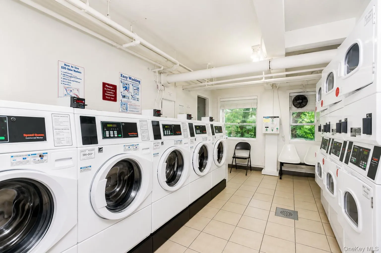 Facility with multiple front-load commercial washers and stacked commercial dryers Facility with multiple front-load commercial washers and stacked commercial dryers
