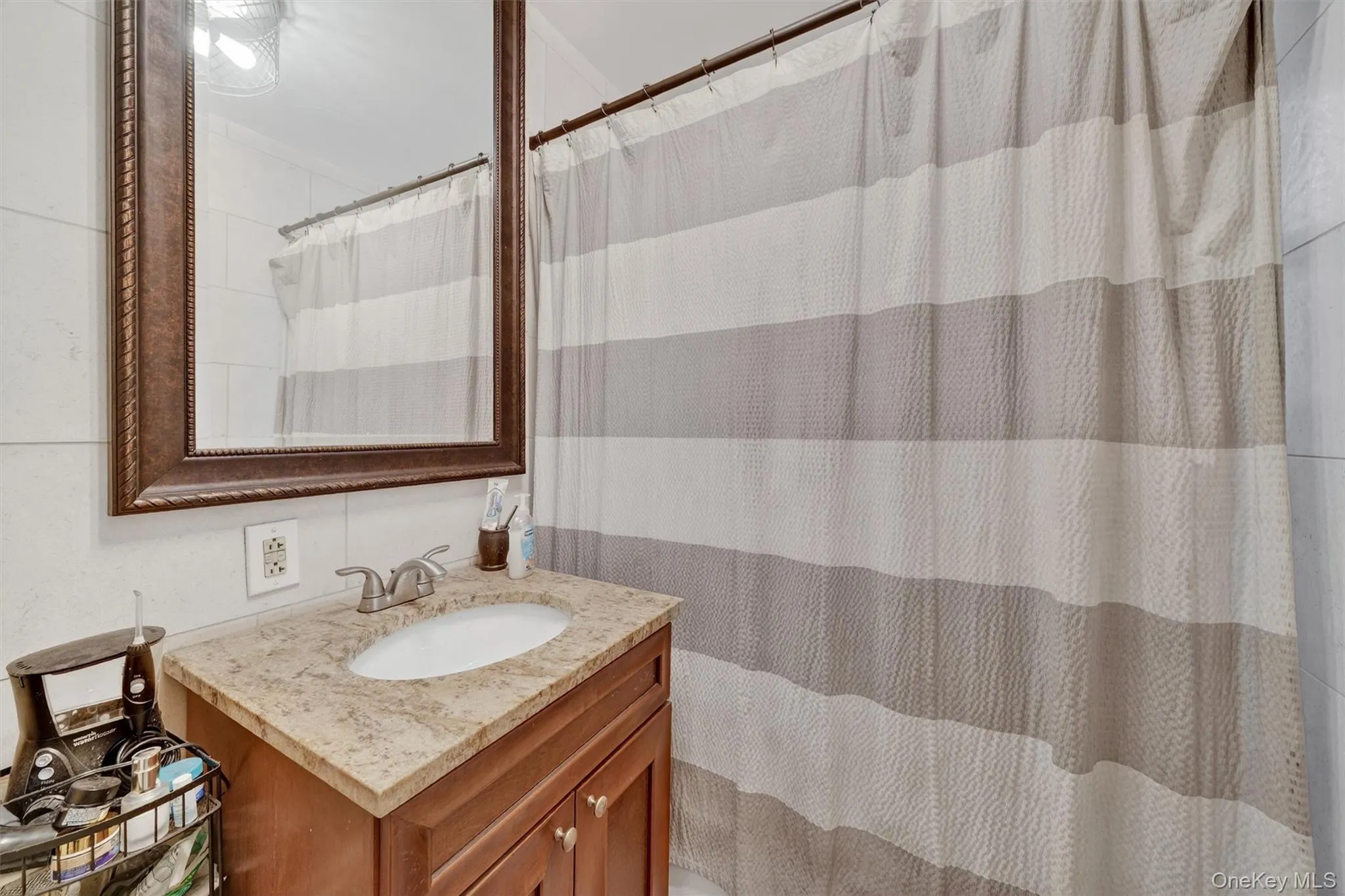 Full bathroom featuring vanity and curtained shower Full bathroom featuring vanity and curtained shower
