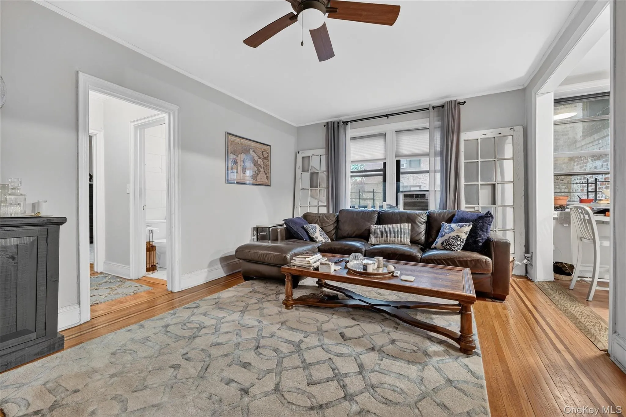 Living area with crown molding, light wood-style flooring, and ceiling fan Living area with crown molding, light wood-style flooring, and ceiling fan