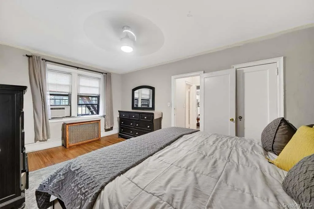 Bedroom featuring radiator, wood finished floors, a ceiling fan, and crown molding Bedroom featuring radiator, wood finished floors, a ceiling fan, and crown molding