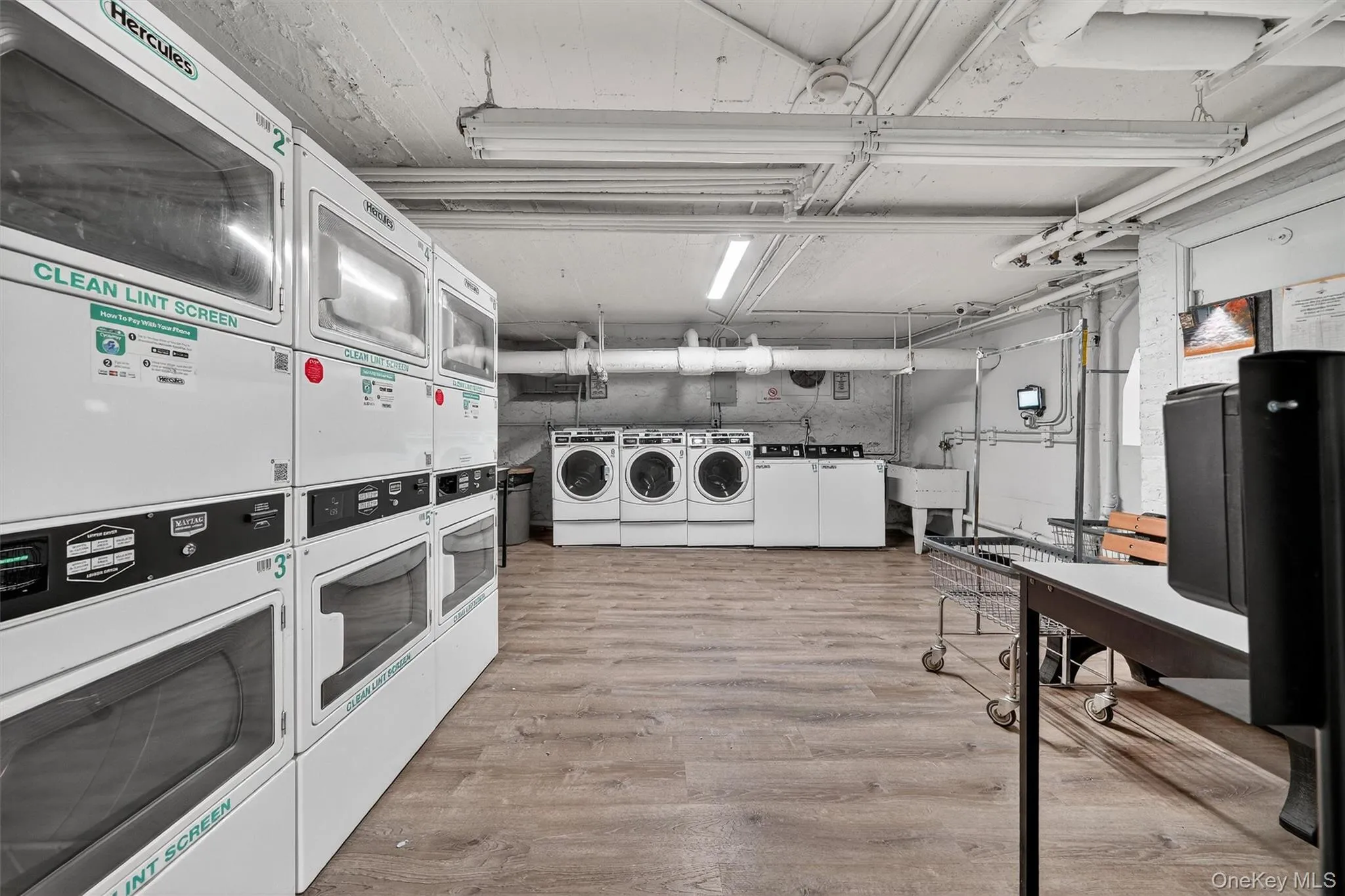 Communal laundry room with stacked washer / dryer and washing machine and dryer Communal laundry room with stacked washer / dryer and washing machine and dryer