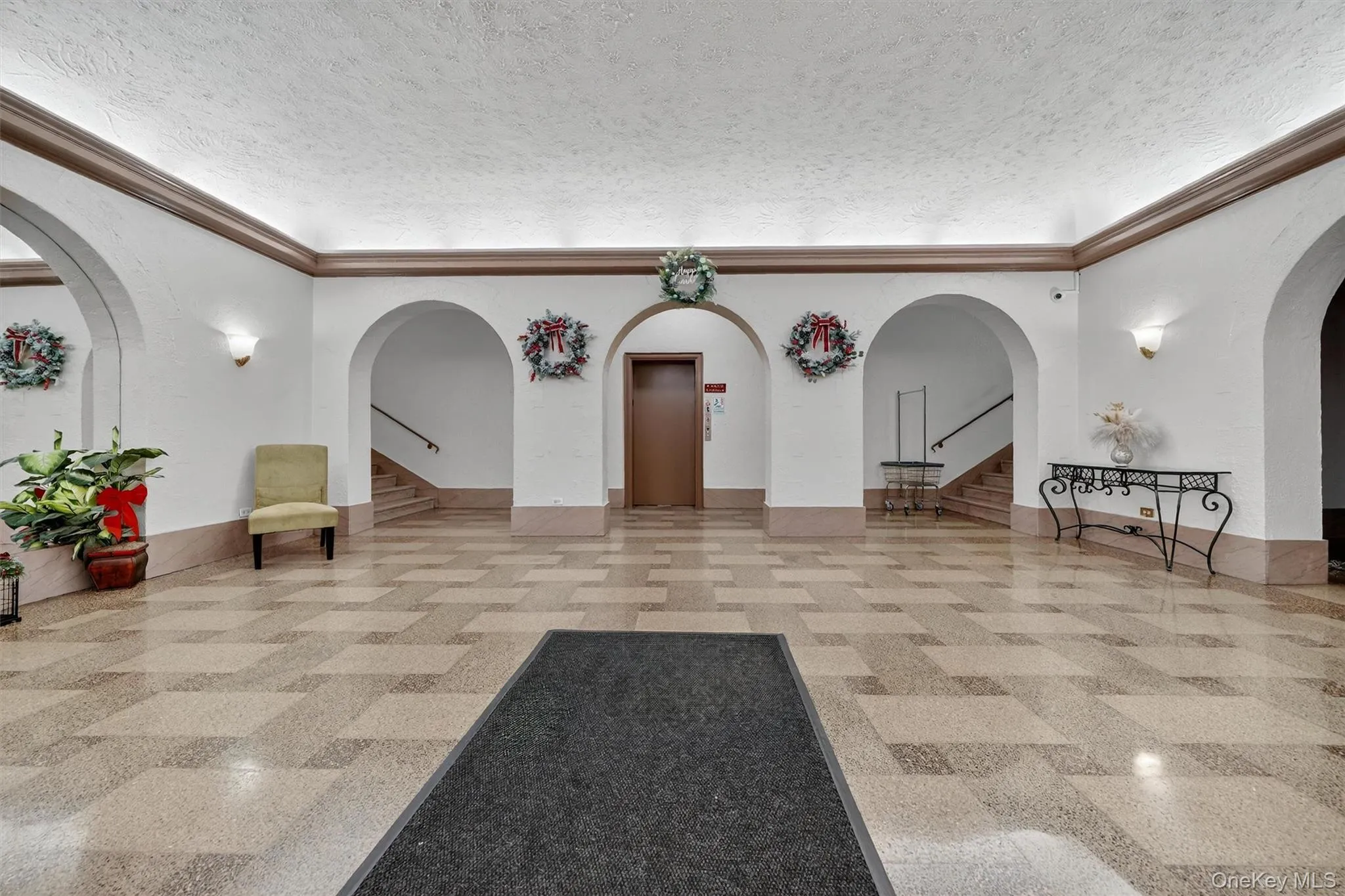 Community lobby with stairway, a textured ceiling, and ornamental molding Community lobby with stairway, a textured ceiling, and ornamental molding