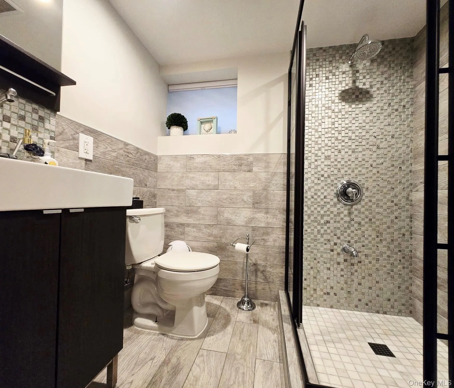 Shower with mosaic tile surround and glass enclosure Shower with mosaic tile surround and glass enclosure