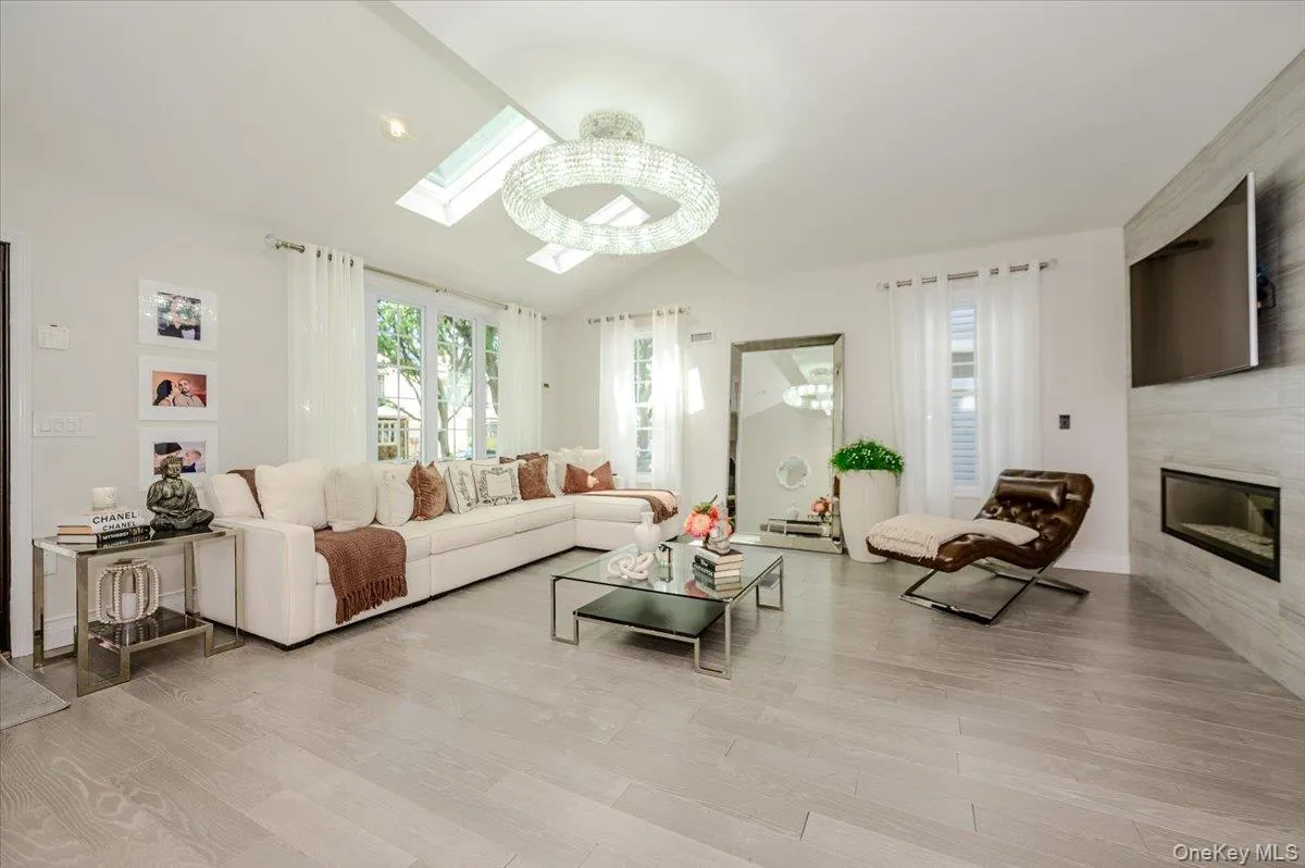 Vaulted ceiling with skylights, wood-finish flooring, built-in fireplace, and expansive glass doors Vaulted ceiling with skylights, wood-finish flooring, built-in fireplace, and expansive glass doors