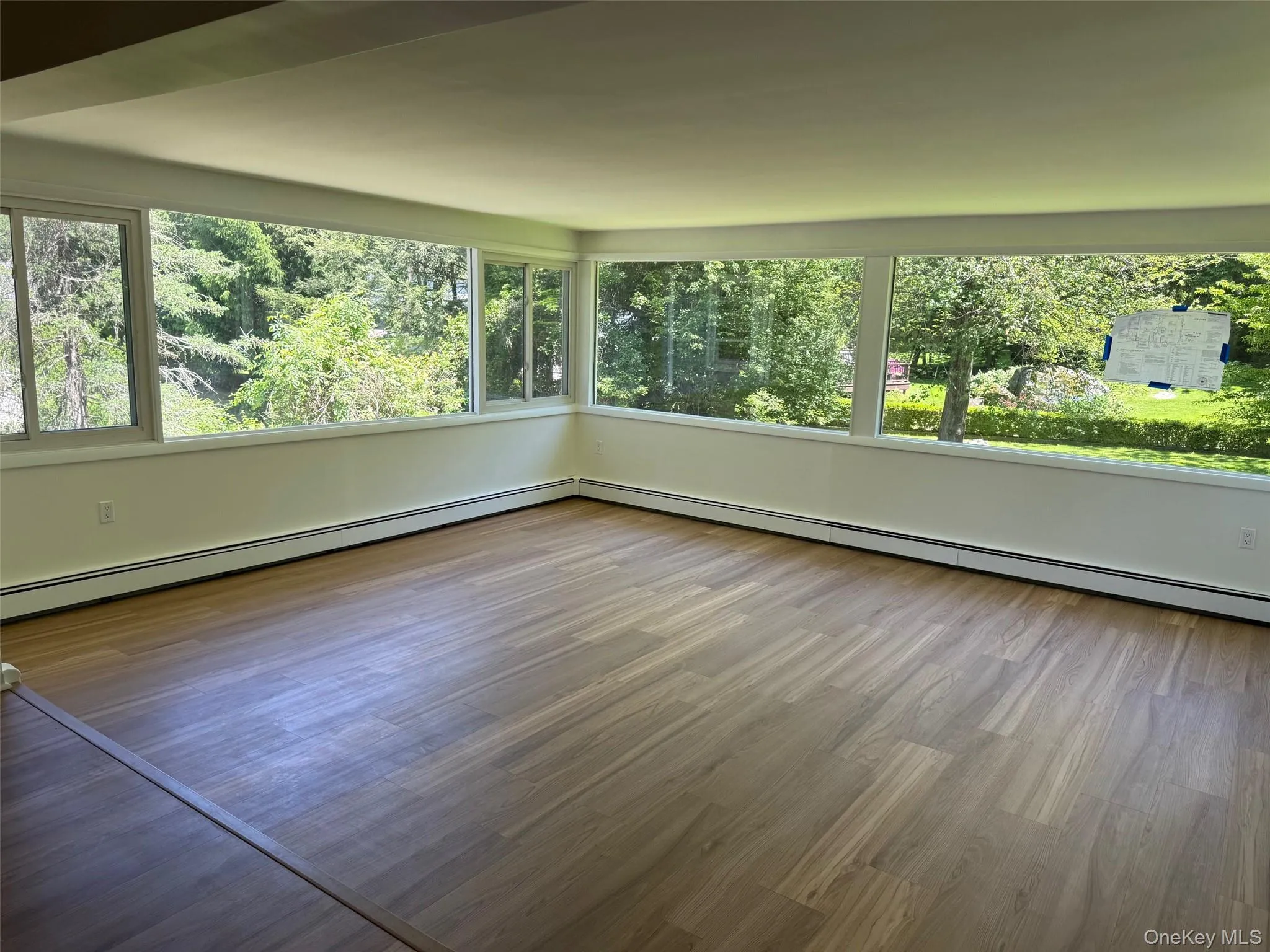 Unfurnished sunroom with healthy amount of natural light and a baseboard heating unit Unfurnished sunroom with healthy amount of natural light and a baseboard heating unit
