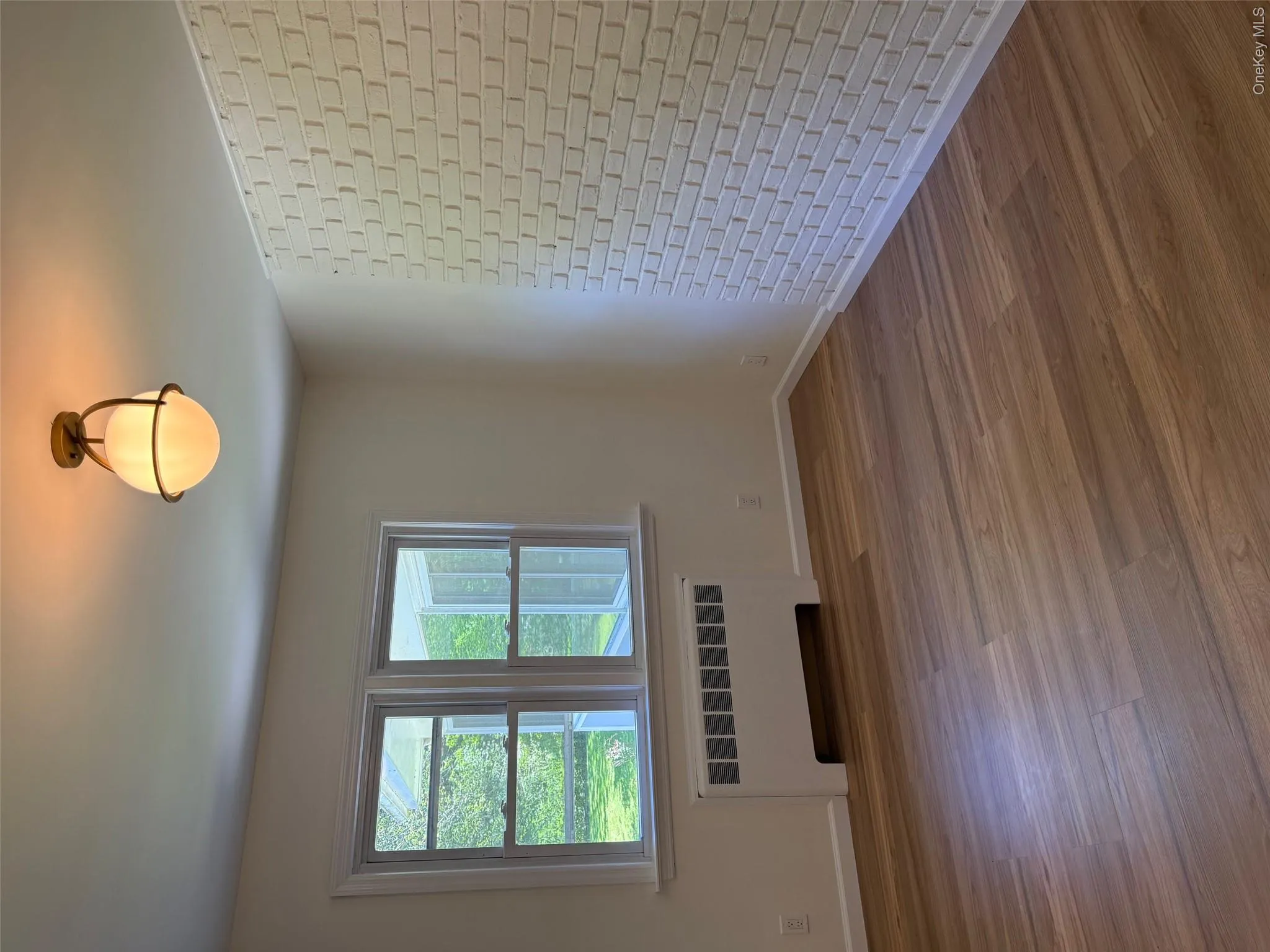 Spare room featuring radiator, wood finished floors, and baseboards Spare room featuring radiator, wood finished floors, and baseboards