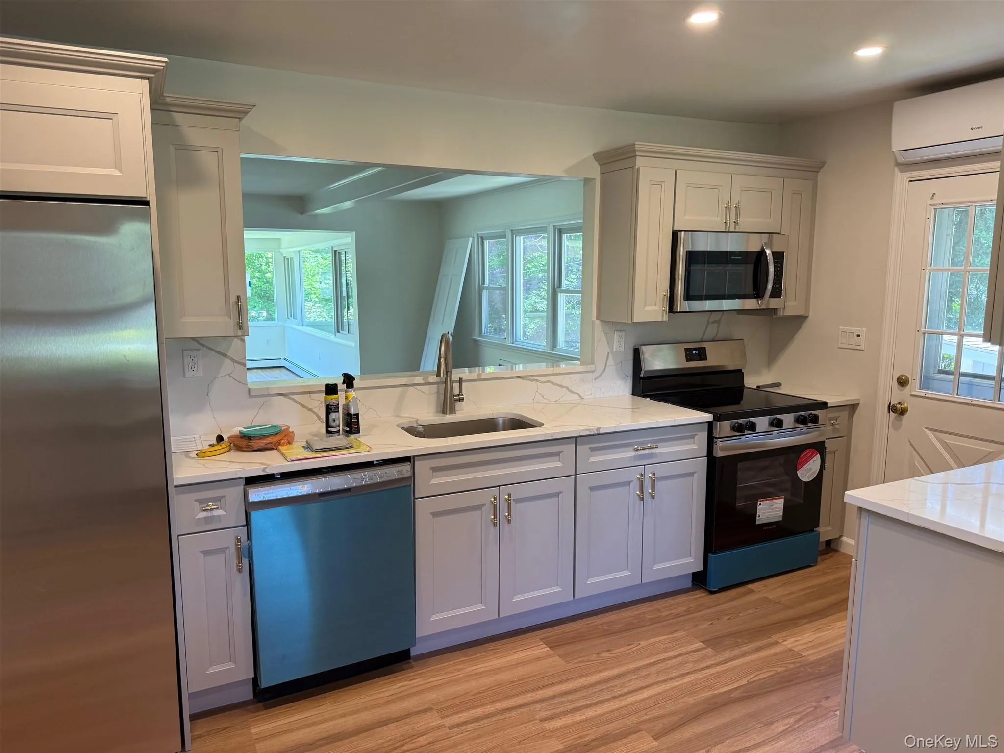 Kitchen with appliances with stainless steel finishes, a sink, gray cabinetry, recessed lighting, and light wood-type flooring Kitchen with appliances with stainless steel finishes, a sink, gray cabinetry, recessed lighting, and light wood-type flooring