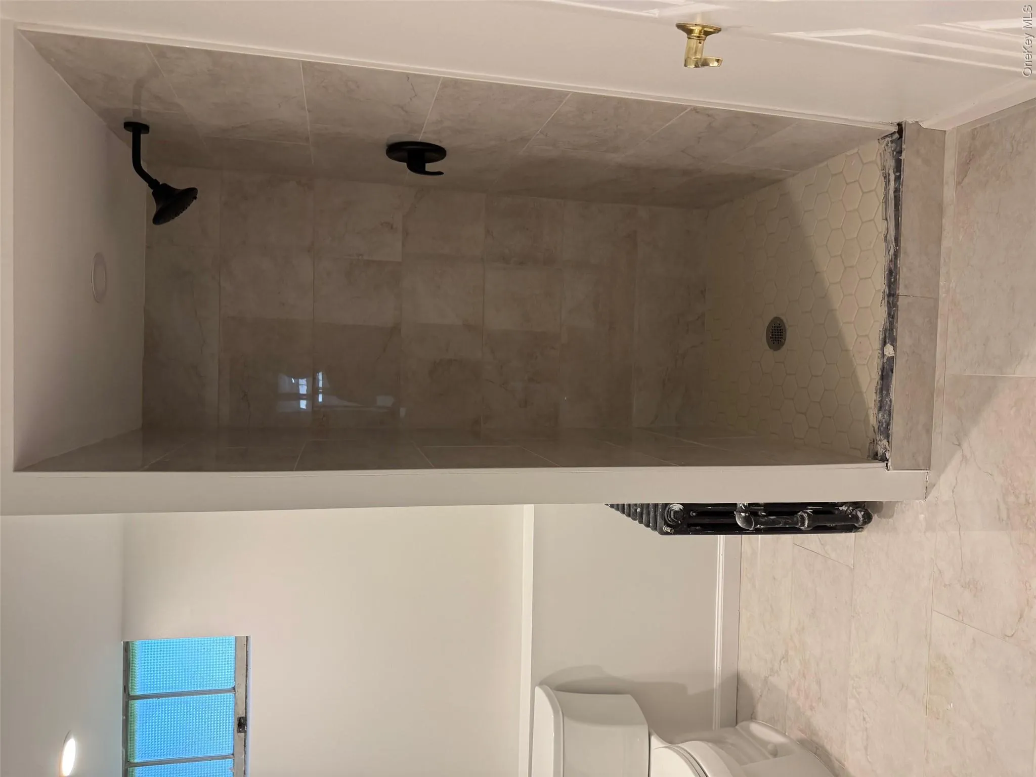 Bathroom with toilet, a stall shower, and baseboards Bathroom with toilet, a stall shower, and baseboards