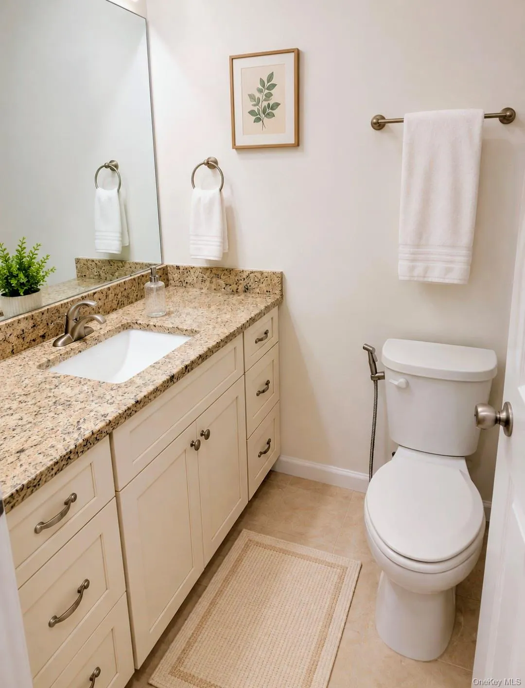 Bathroom featuring a vanity with stone countertop, integrated sink, and white cabinetry Bathroom featuring a vanity with stone countertop, integrated sink, and white cabinetry