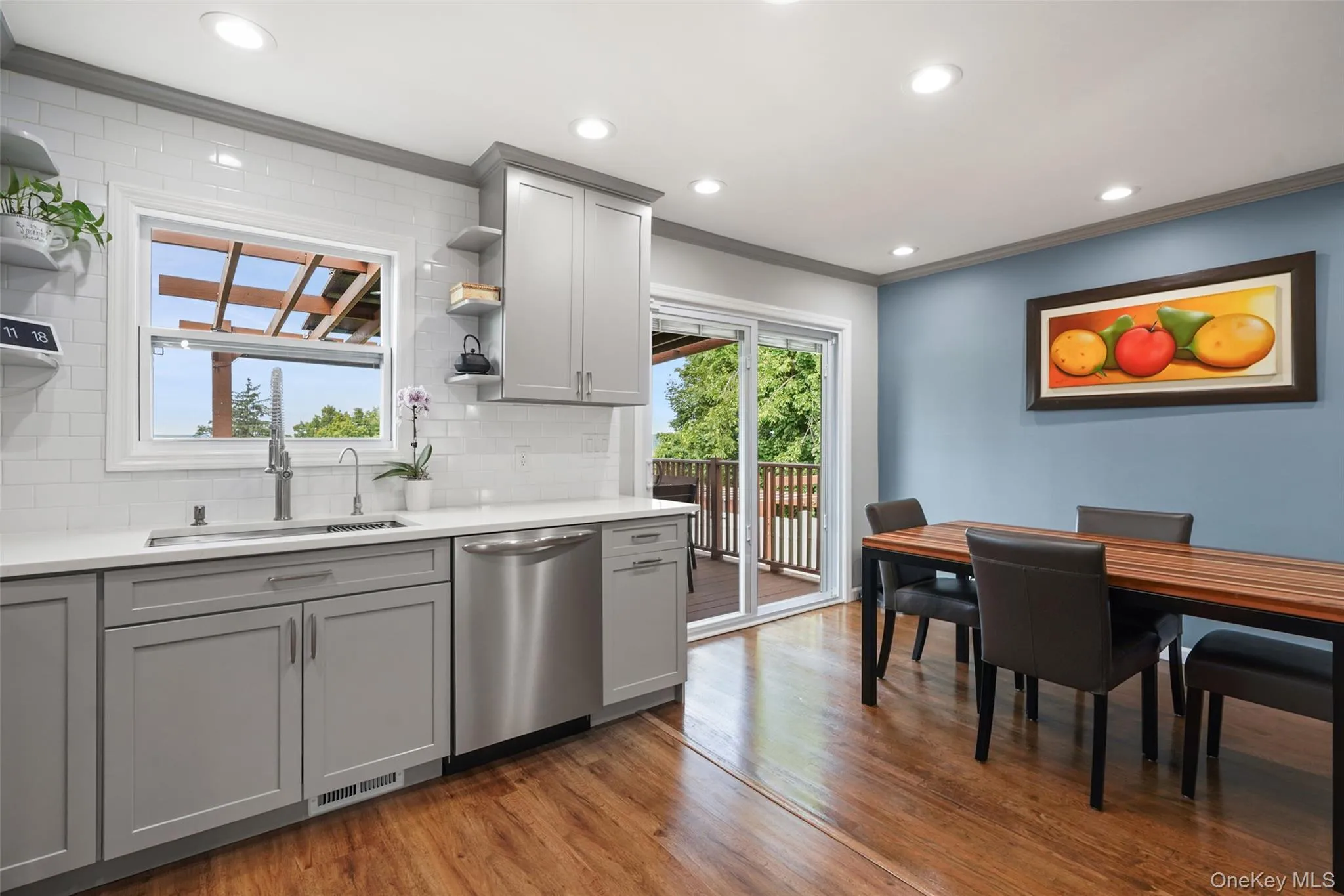 Recessed lighting, wood-finish flooring, light gray cabinetry, stainless steel appliances, and quartz countertops Recessed lighting, wood-finish flooring, light gray cabinetry, stainless steel appliances, and quartz countertops