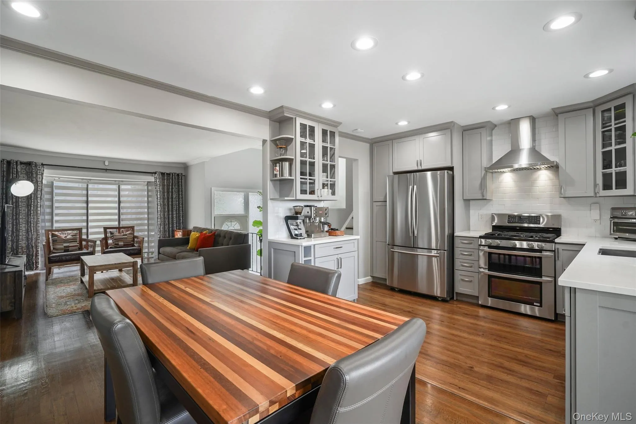 Recessed lighting, wood-finish flooring, light gray cabinetry, stainless steel appliances, and quartz countertops Recessed lighting, wood-finish flooring, light gray cabinetry, stainless steel appliances, and quartz countertops