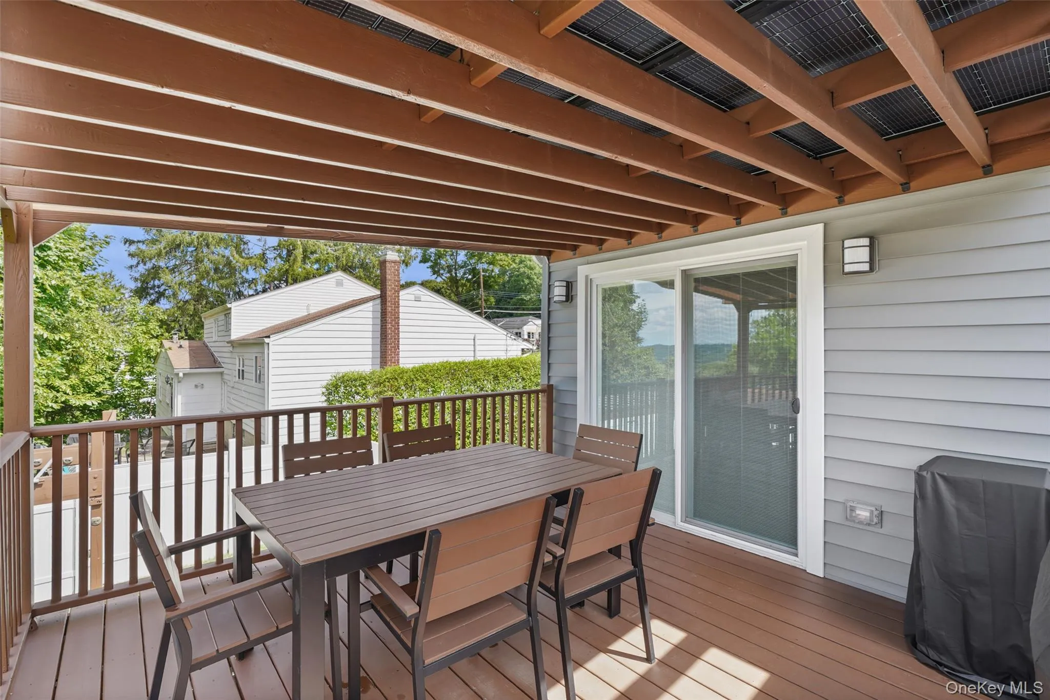 Multi-level wood-finish deck with integrated pergola, privacy railing, and built-in staircase Multi-level wood-finish deck with integrated pergola, privacy railing, and built-in staircase