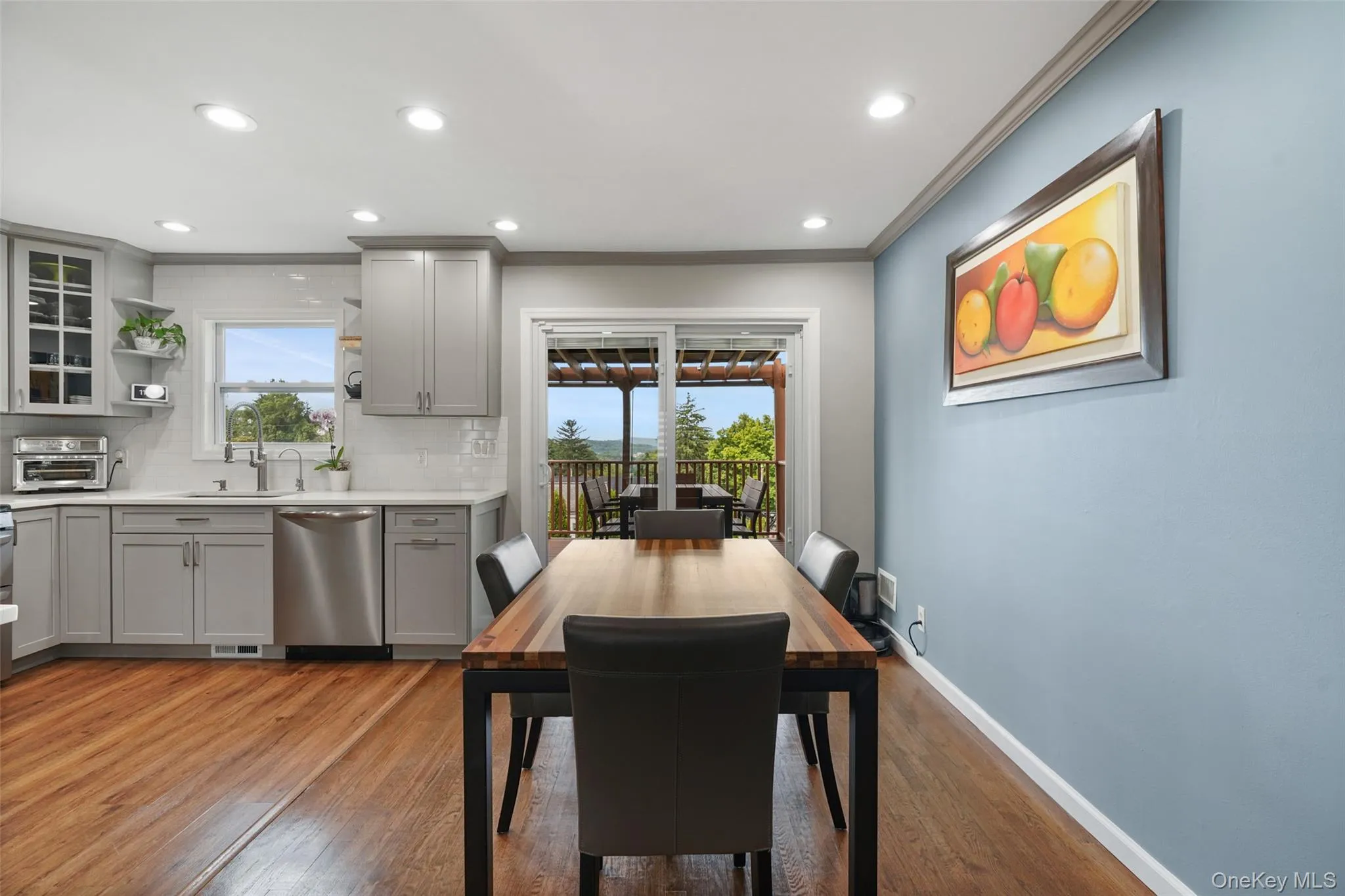 Recessed lighting, wood-finish flooring, light gray cabinetry, stainless steel appliances, and quartz countertops Recessed lighting, wood-finish flooring, light gray cabinetry, stainless steel appliances, and quartz countertops
