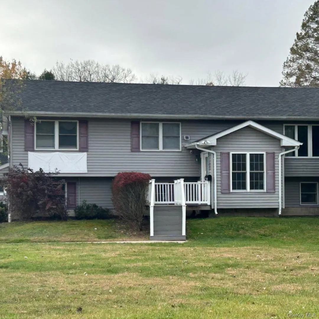 Split foyer home featuring a wooden deck and a front lawn Split foyer home featuring a wooden deck and a front lawn