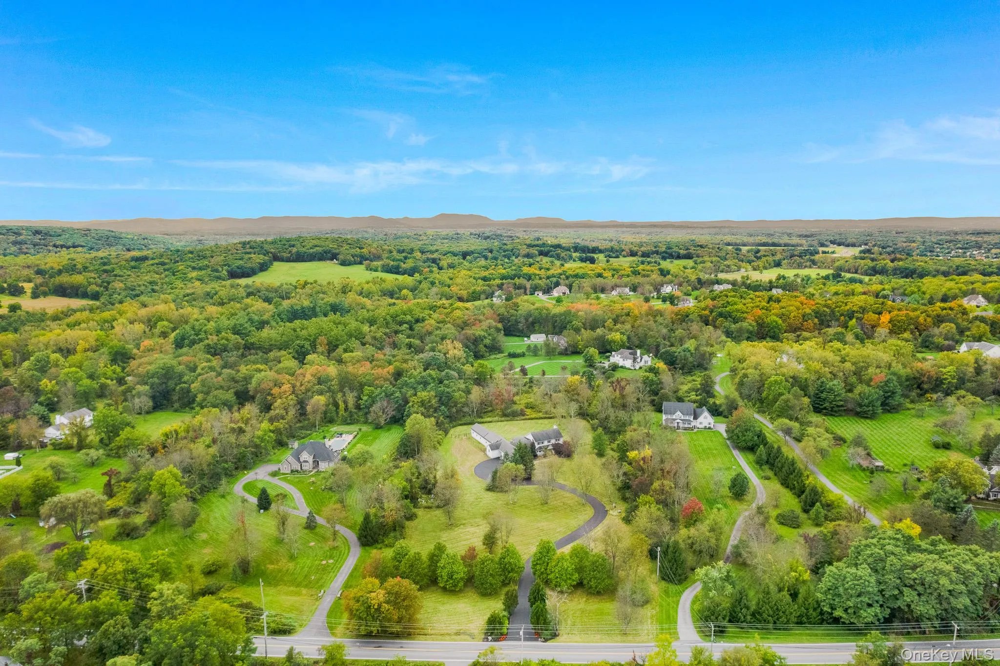 Expansive property featuring a winding paved driveway and a vast amount of surrounding mature trees. Expansive property featuring a winding paved driveway and a vast amount of surrounding mature trees.