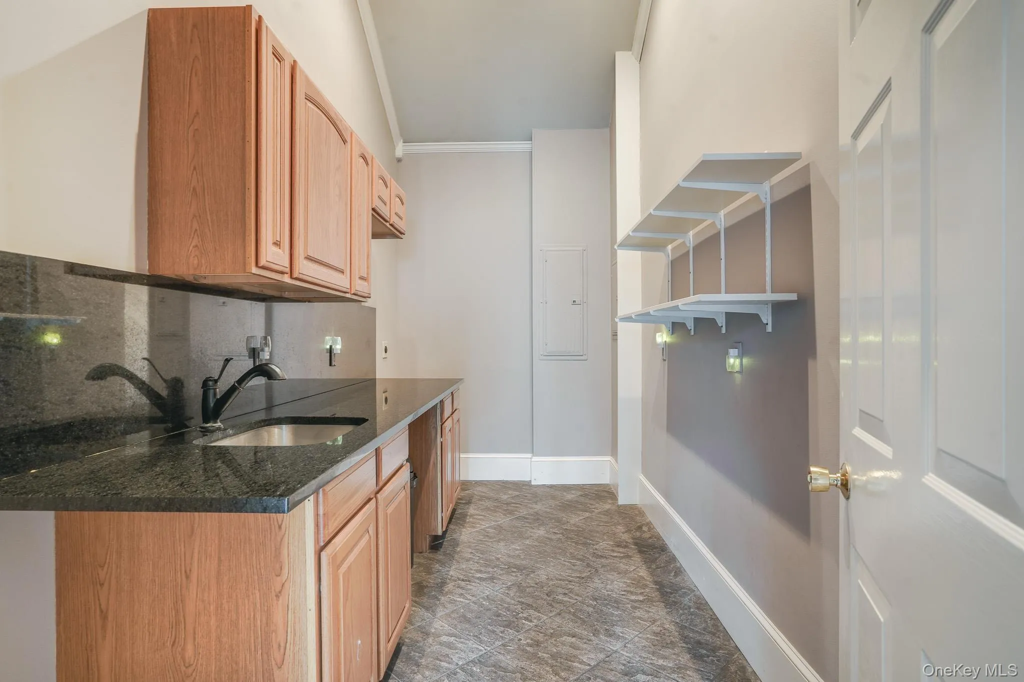 Butler's kitchen or laundry area with additional storage, wetbar, and tile flooring. Butler's kitchen or laundry area with additional storage, wetbar, and tile flooring.
