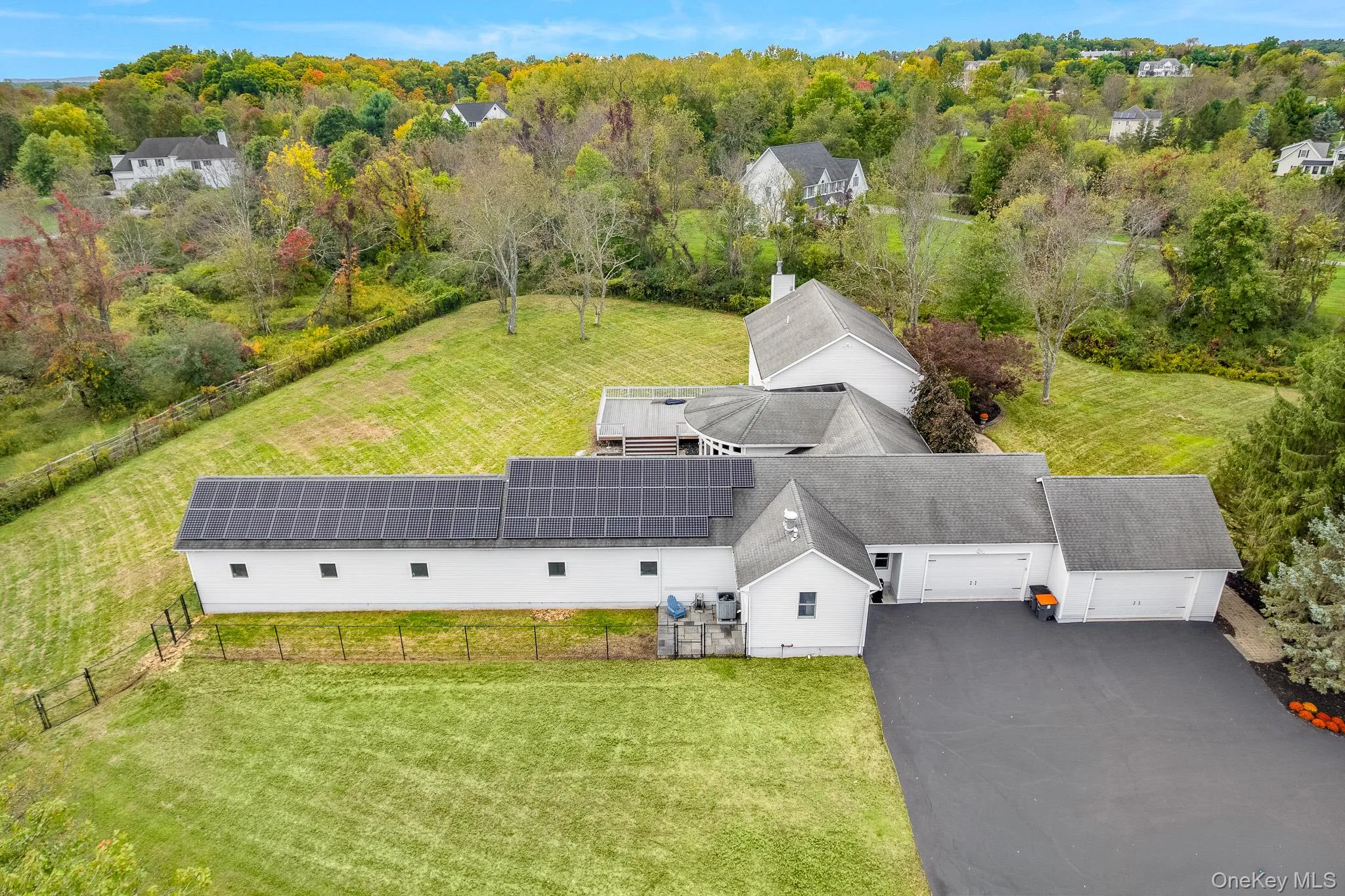 Extensive solar panel array, multi-car garage, expansive green space, paved driveway, and mature landscaping. Extensive solar panel array, multi-car garage, expansive green space, paved driveway, and mature landscaping.