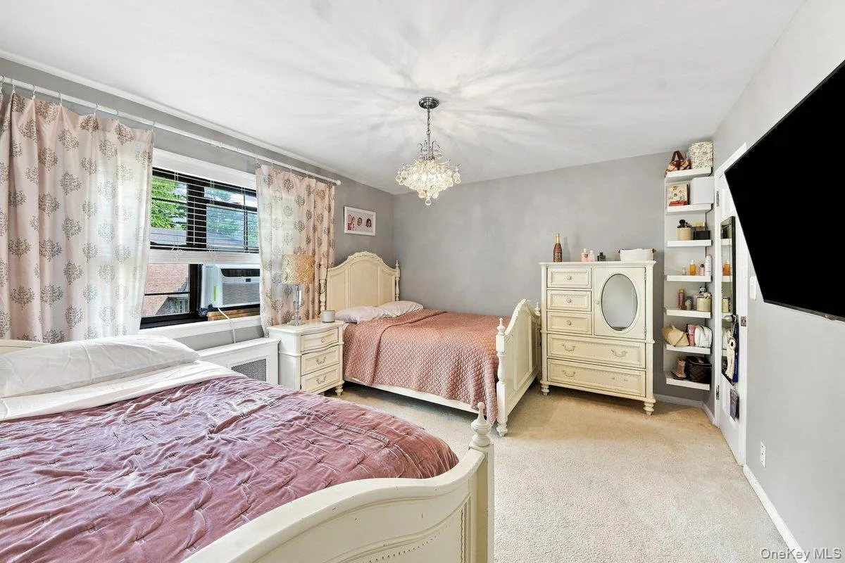 Bright second bedroom with a large window, ample space for two beds, and storage space. Bright second bedroom with a large window, ample space for two beds, and storage space.