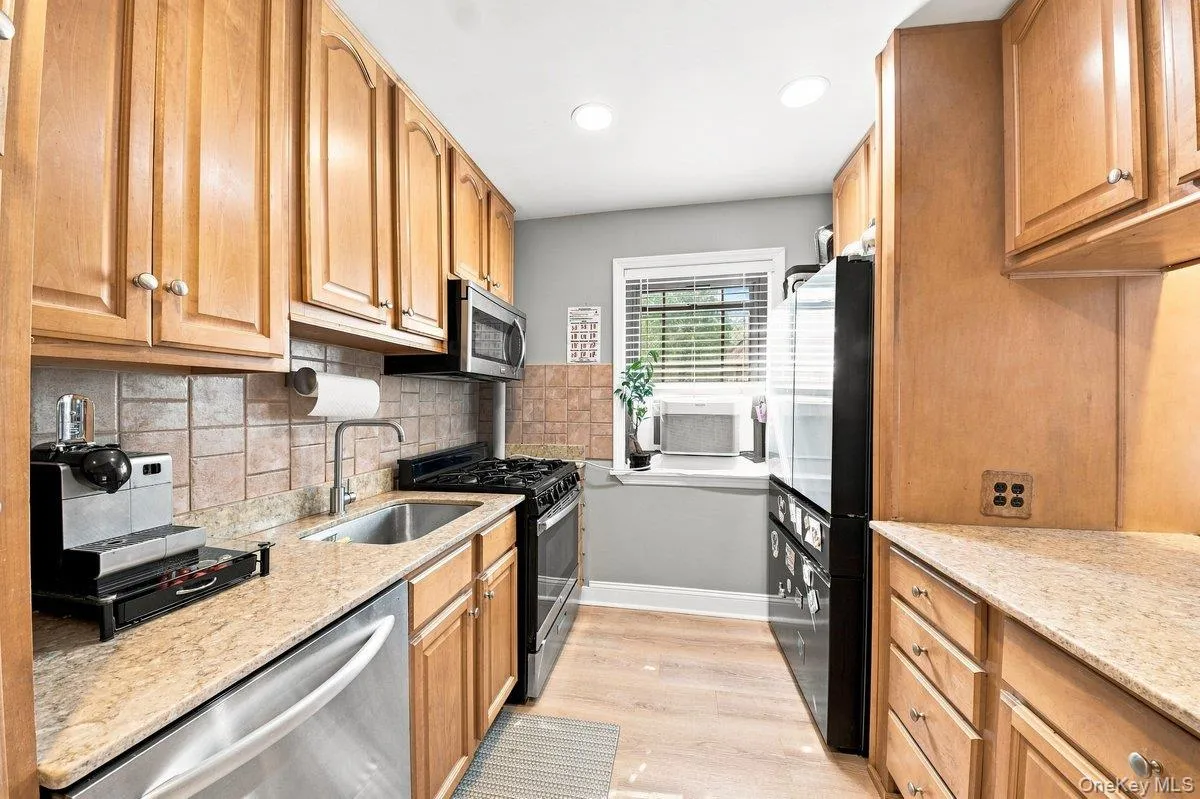 Beautifully maintained kitchen showcasing granite countertops, rich wood cabinetry, stainless steel appliances, and a window that enhances the space with natural light. Beautifully maintained kitchen showcasing granite countertops, rich wood cabinetry, stainless steel appliances, and a window that enhances the space with natural light.