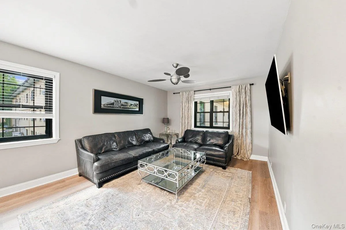 Bright, light-filled living room with two windows providing great natural exposure. Bright, light-filled living room with two windows providing great natural exposure.
