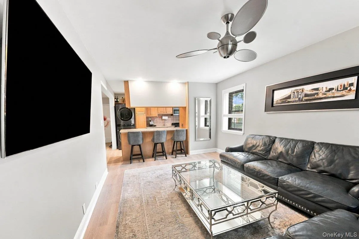 Bright, modern living room with two windows, a sleek granite-top kitchen bar, and a perfectly sized dining area that enhances the open-concept flow. Bright, modern living room with two windows, a sleek granite-top kitchen bar, and a perfectly sized dining area that enhances the open-concept flow.